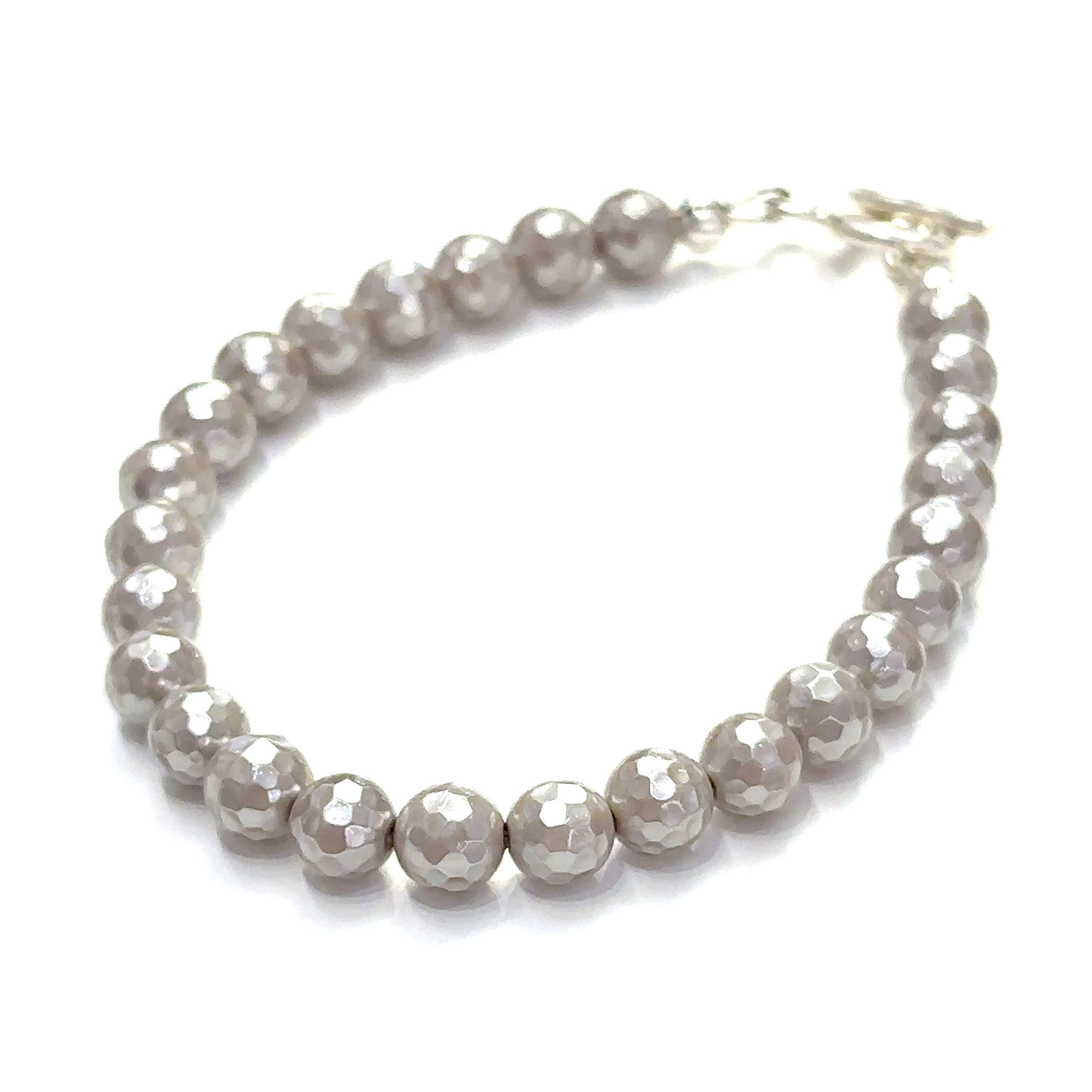 Close-up of iridescent Mother of Pearl beads showing natural shimmer and detail on a white background slight left front overview.