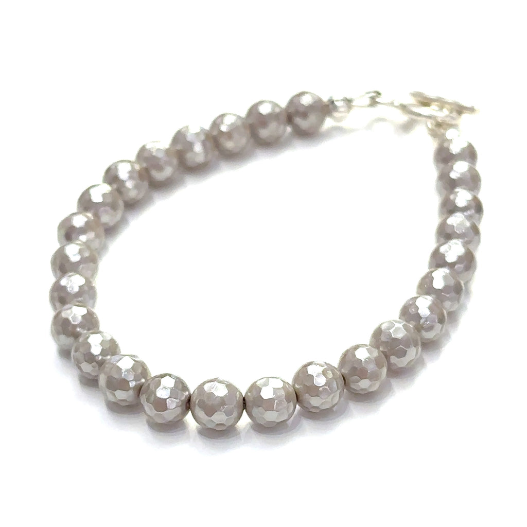 Close-up of iridescent Mother of Pearl beads showing natural shimmer and detail on a white background slight left front overview.