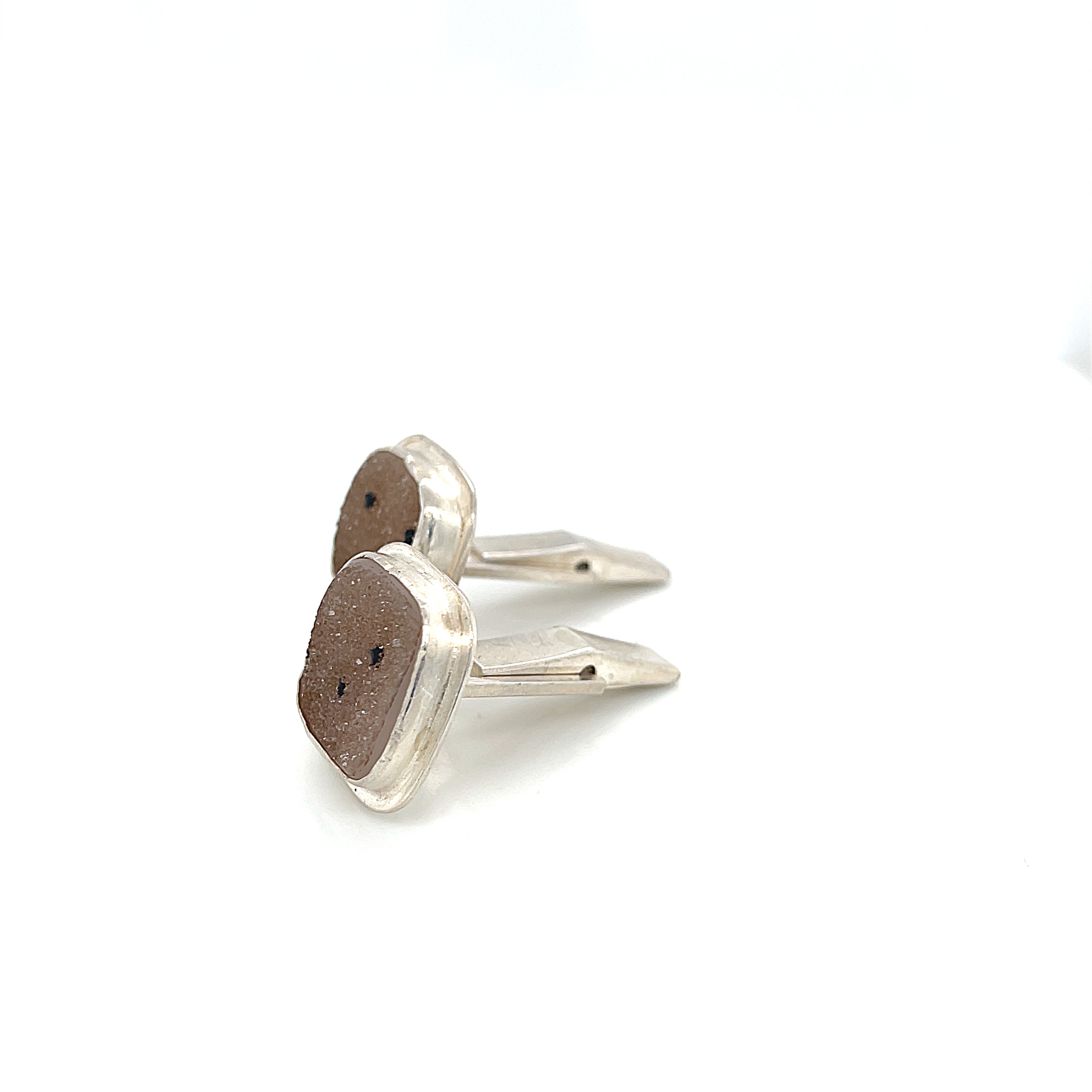 Close-up of natural quartz crystal, druzy texture, with brown inclusions, gemstone, with sterling silver cufflinks on a white background, right side  close up overview.