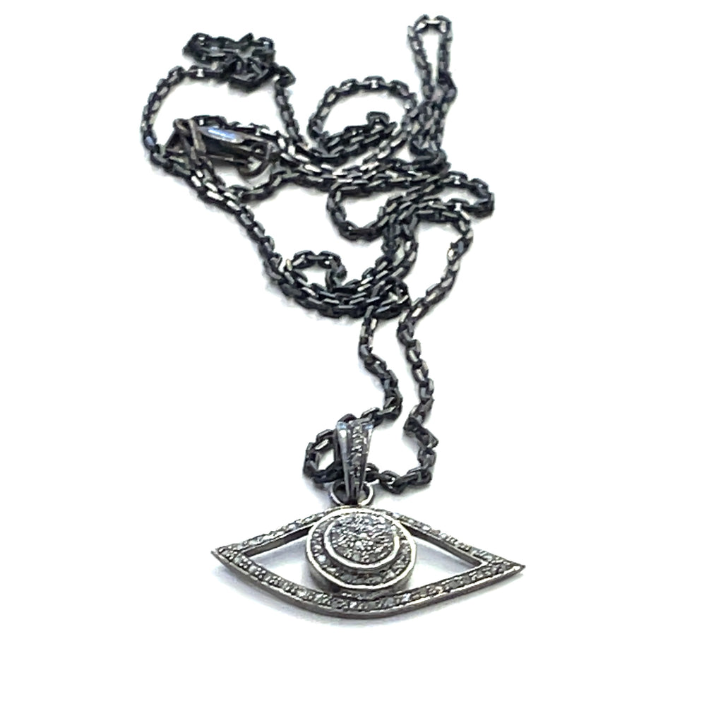 Close-up of pavé diamond Evil Eye pendant showing oxidized texture and sparkle on a white background center long overview.