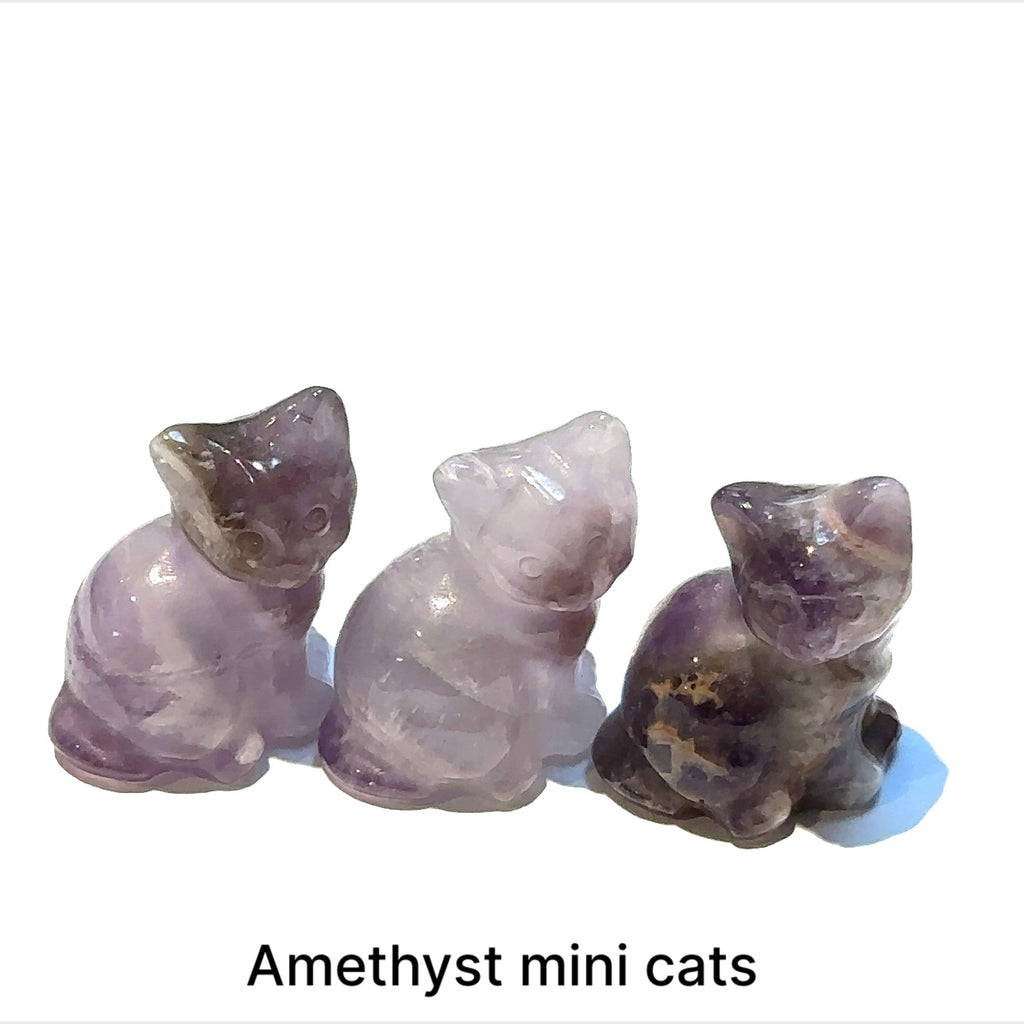 Close-up of polished gemstone cat grouping of Amethyst showing crystal texture and color variation. On white background front overview.