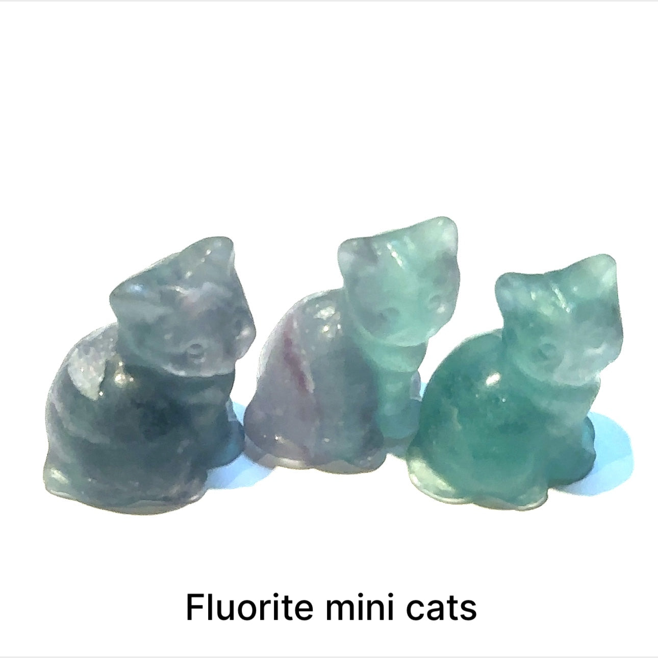 Close-up of polished gemstone cat grouping of Rainbow Fluorite showing crystal texture and color variation. On white background front overview.