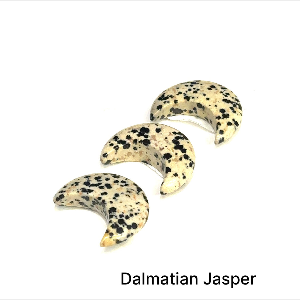 Close-up of polished moon-shaped  Dalmatian Jasper grouping gemstones  on a white background front overview