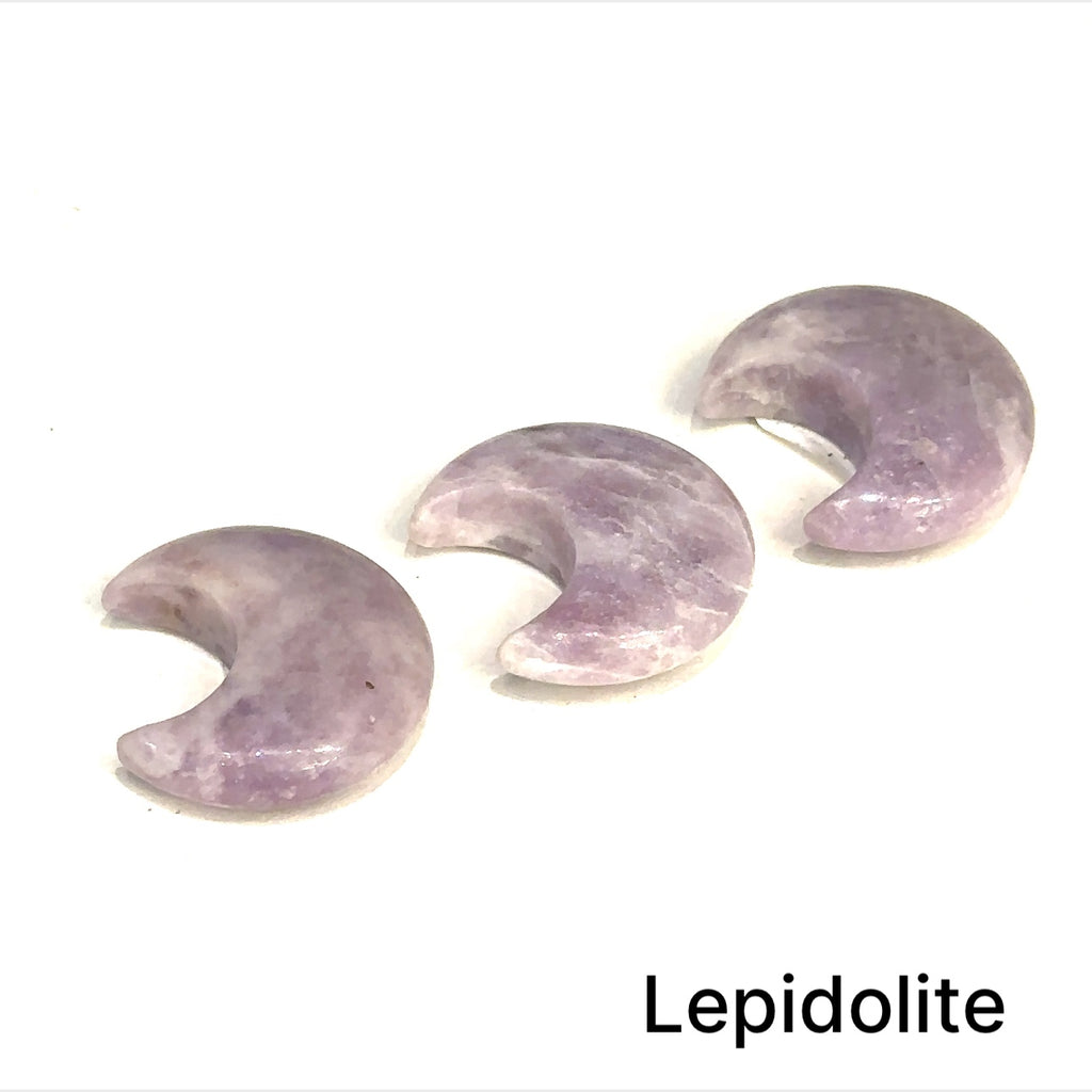 Close-up of polished moon-shaped Lepidolite gemstones arranged in rows on a white background front view