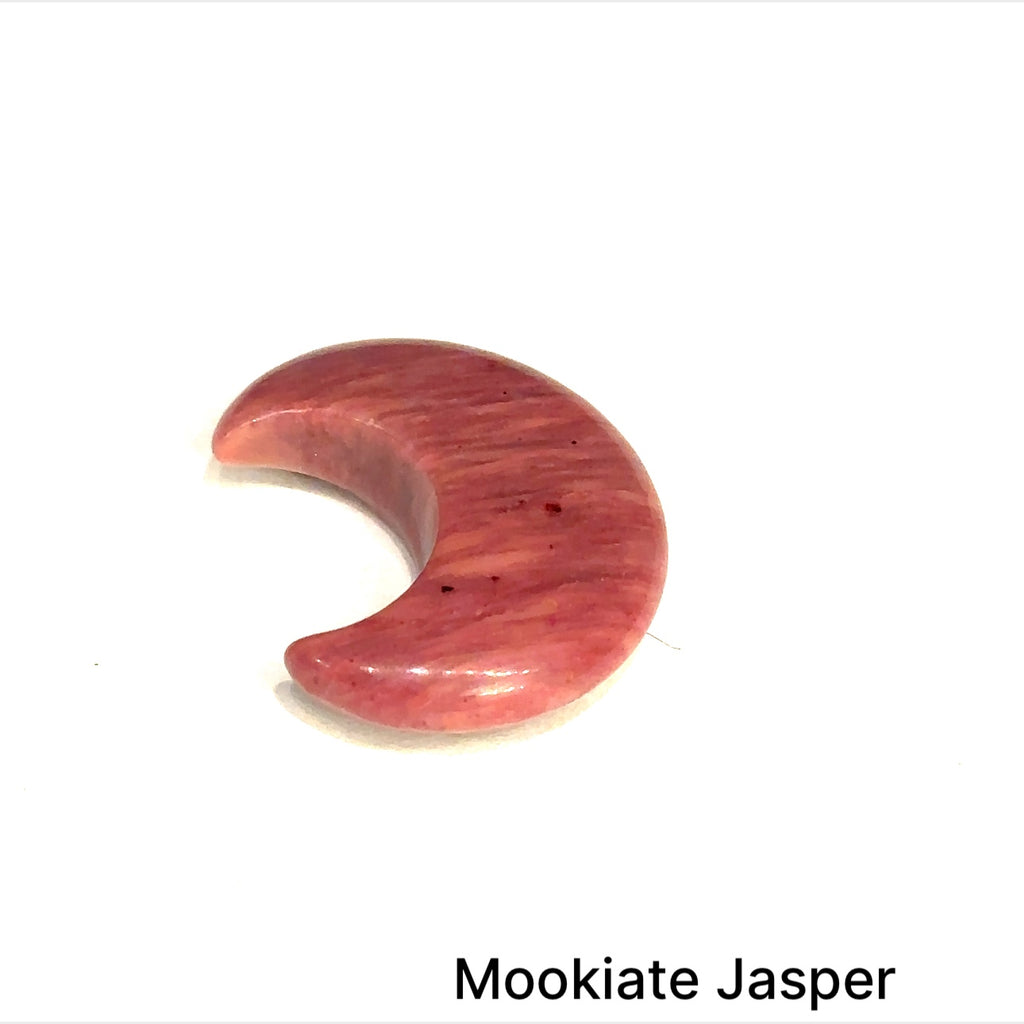Close-up of polished moon-shaped Mookiate Jasper gemstones on a white background front view