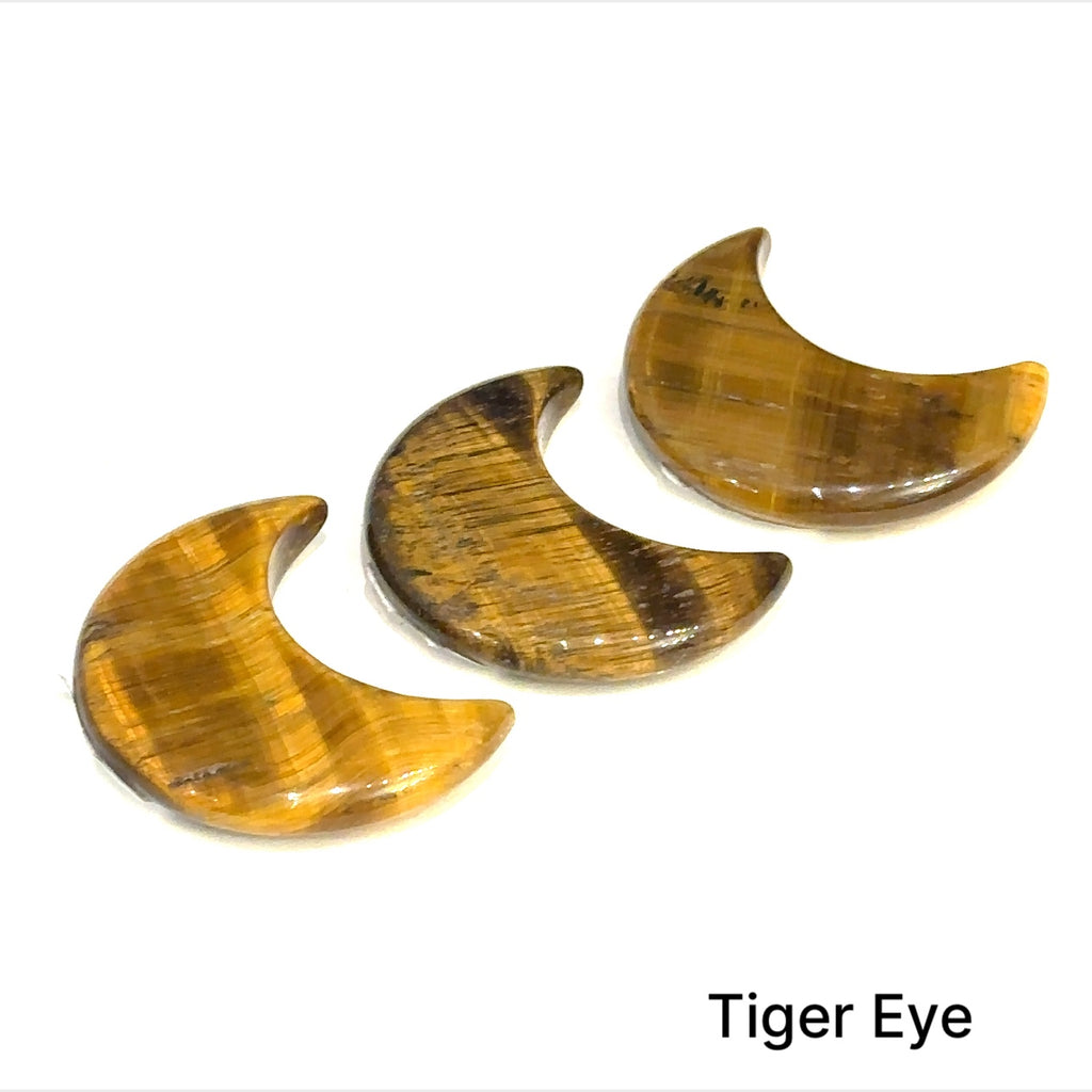 Close-up of polished moon-shaped Tiger Eye gemstones grouping on a white background front overview