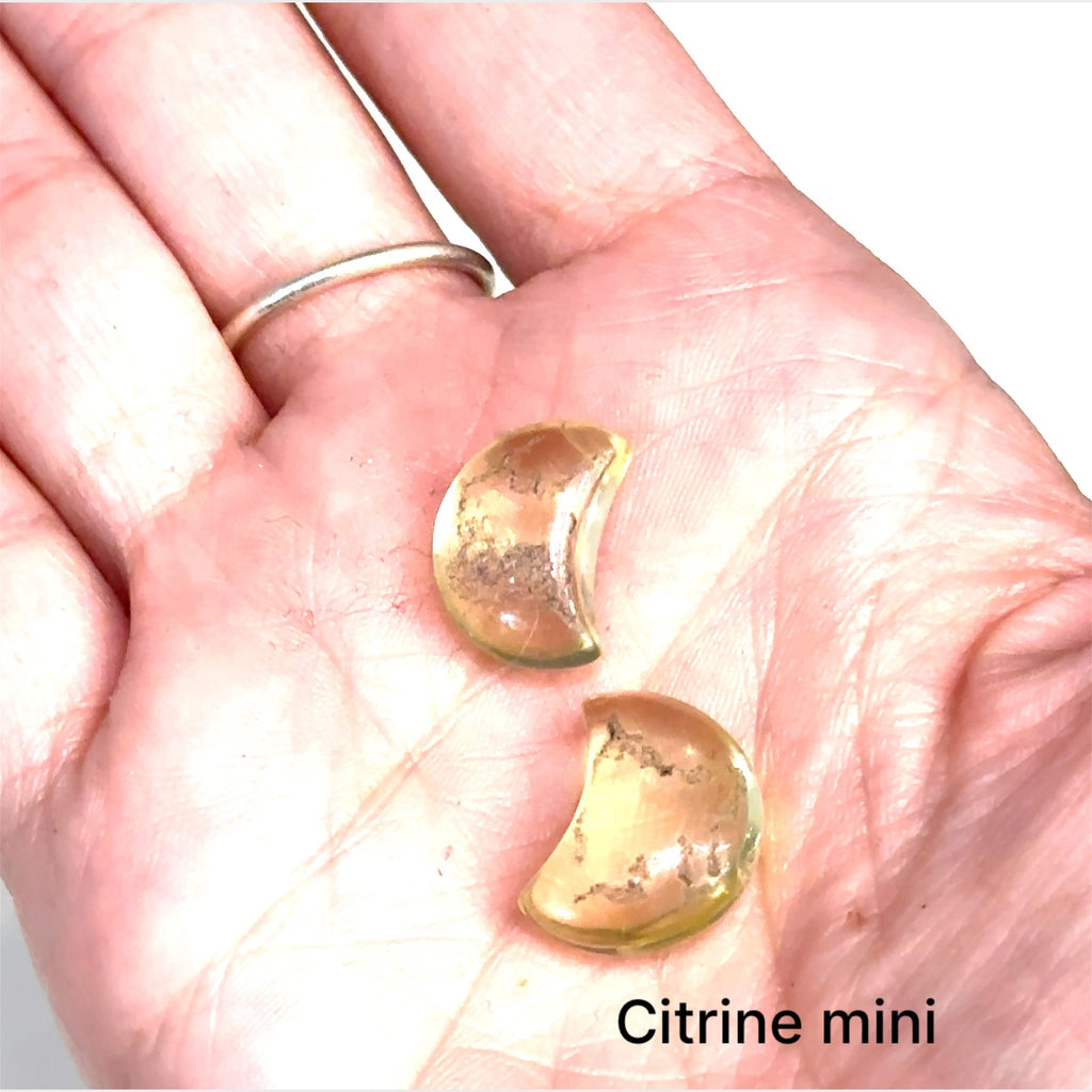 Close-up of polished moon-shaped  mini Citrine  gemstones grouping on a white background front overview
