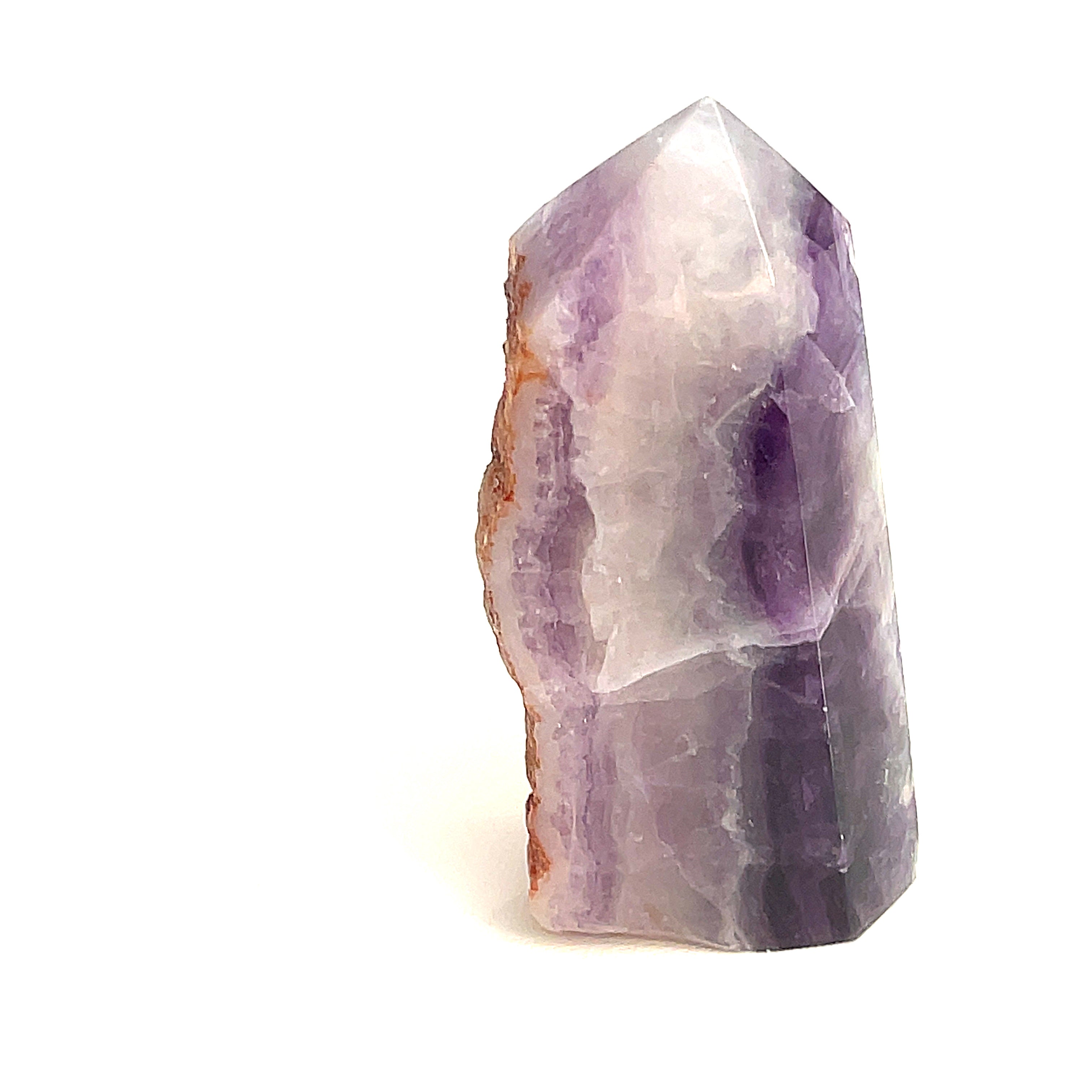 Close-up of purple Fluorite showing translucent layers a white background, sideview. 