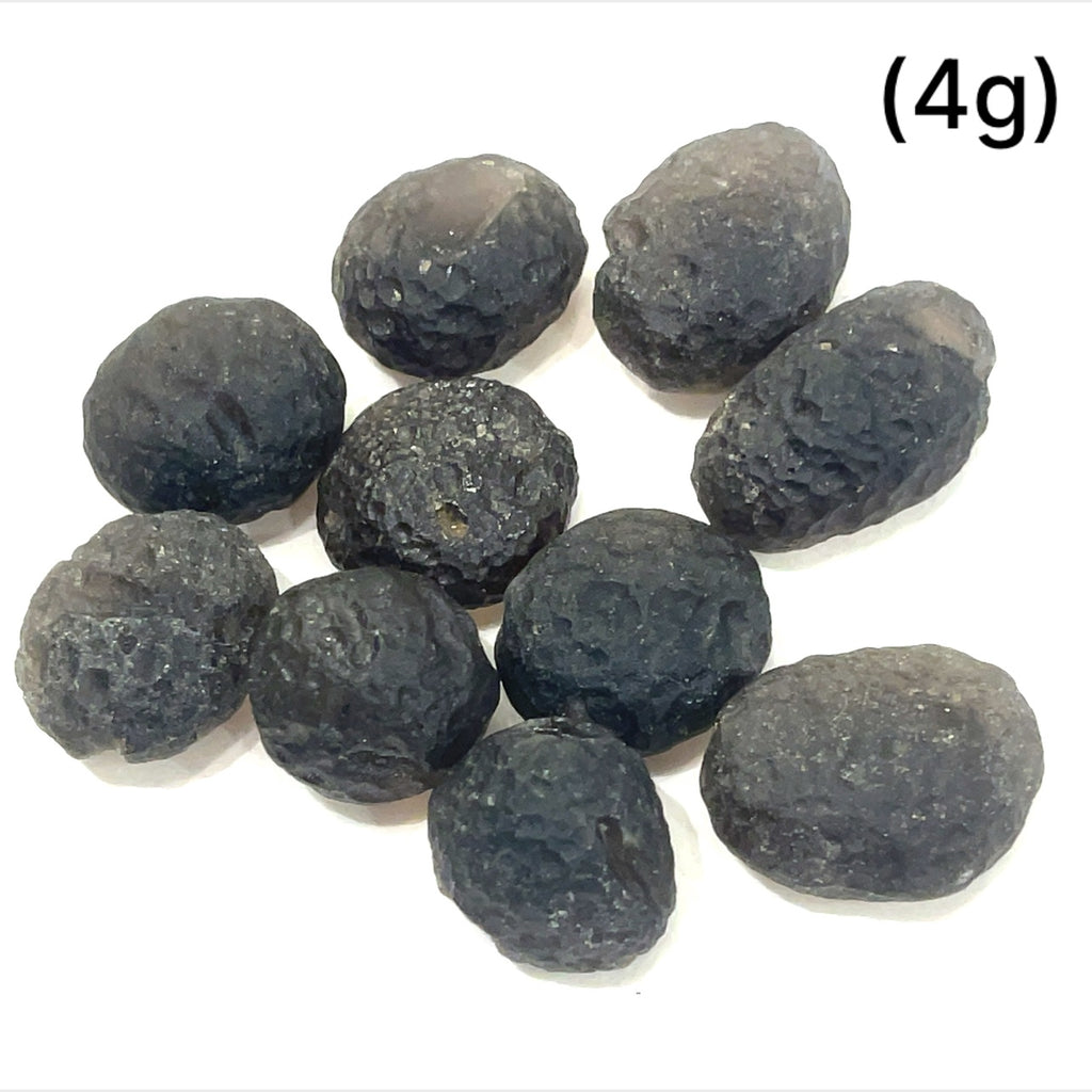 Detailed shot of authentic Colombianite obsidian “Piedra Rayo” gemstone sizes (4g) on white background overview.