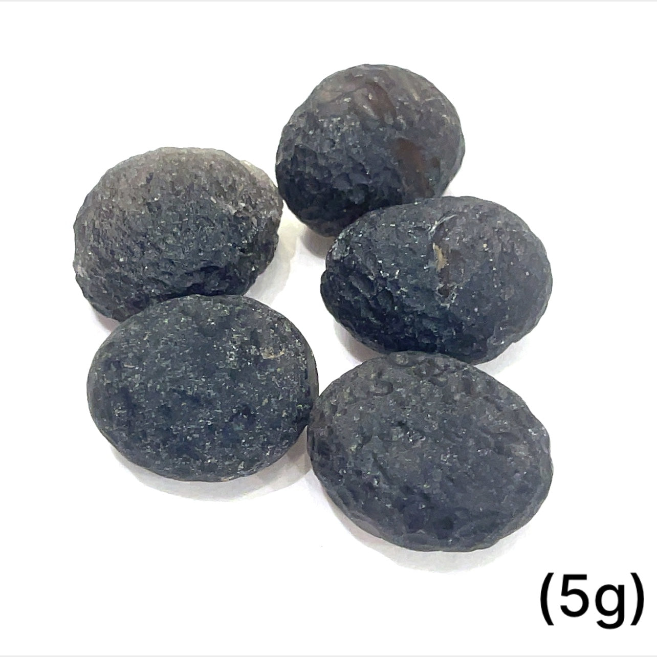 Detailed shot of authentic Colombianite obsidian “Piedra Rayo” gemstone sizes (5g) on white background overview.