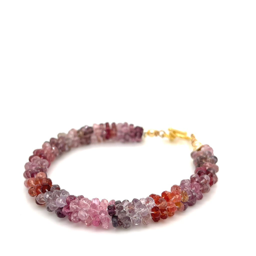 Faceted red gemstone bracelet — handmade spiritual jewelry on a white background front slight left angle view.