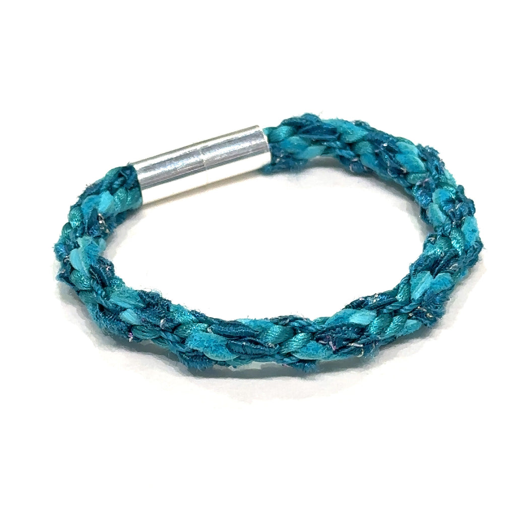Finished teal Kumihimo bracelet with magnetic clasp shown on white background overview