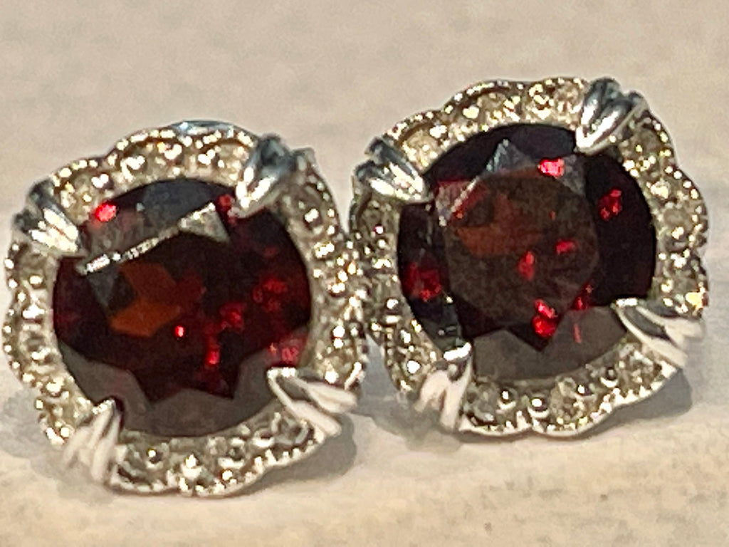 Garnet Diamond Stud Earrings, straight-on view on a tan background. 