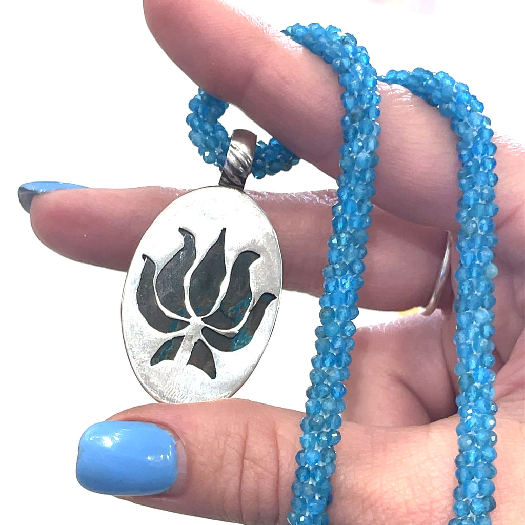 Gem Silica Druzy in Matrix pendant from Australia set in sterling silver in models hand to showing the pendant on white background back pendant view. 