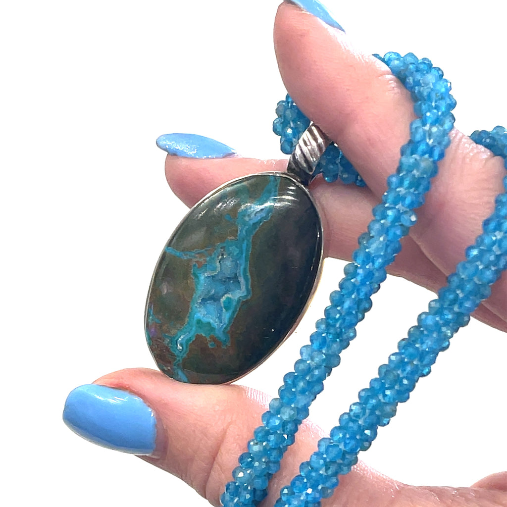 Gem Silica Druzy in Matrix pendant from Australia set in sterling silver in models hand to showing the pendant on white background pendant view. 