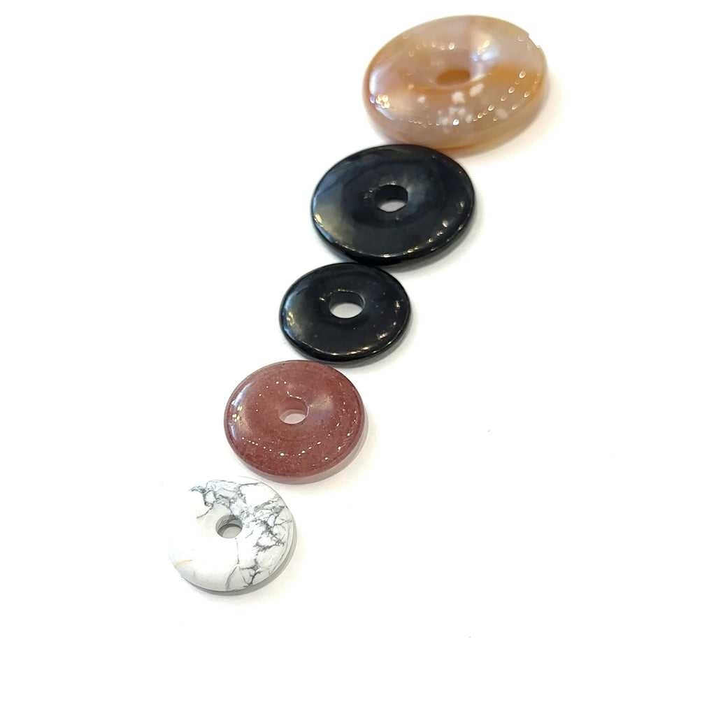 Gemstone donut collection featuring Flower Agate, Shungite, and Howlite stones on white background overview 