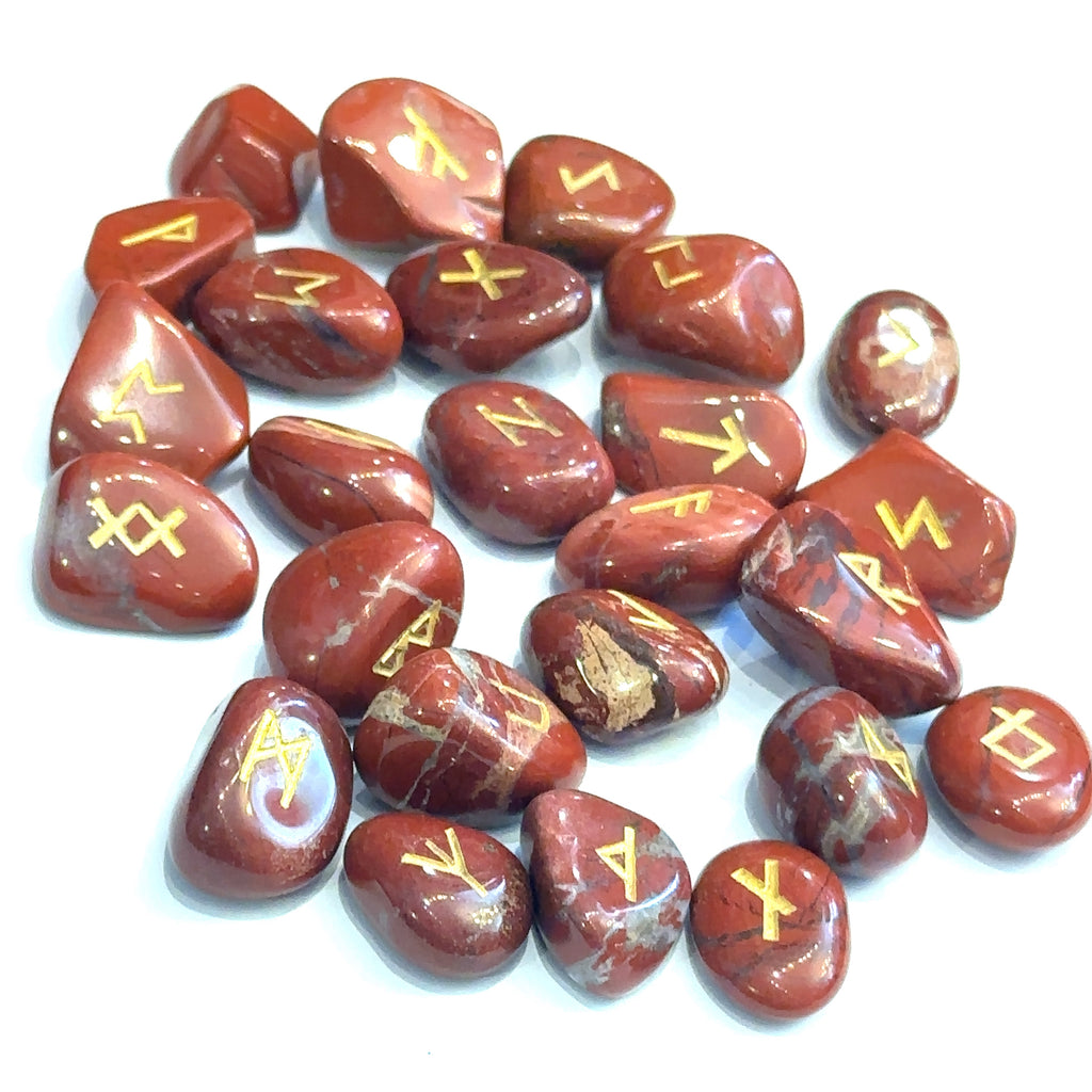 Gemstone rune set with engraved symbols on polished stones, representing divination and reflection red jasper grouping on white overview