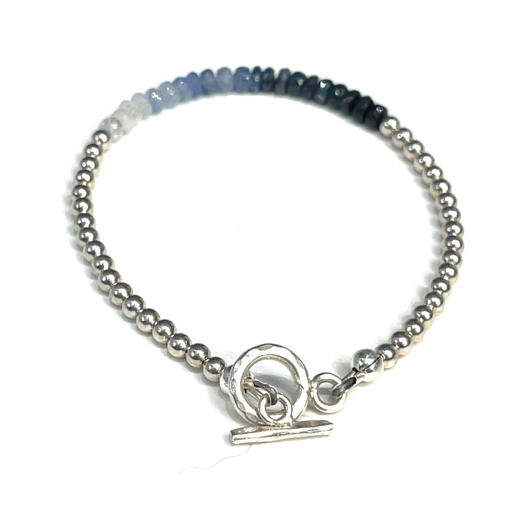 Genuine Sapphire gemstone bracelet with sterling silver beads and  toggle clasp by Hidden Jewel on a white background toggle back overview. 