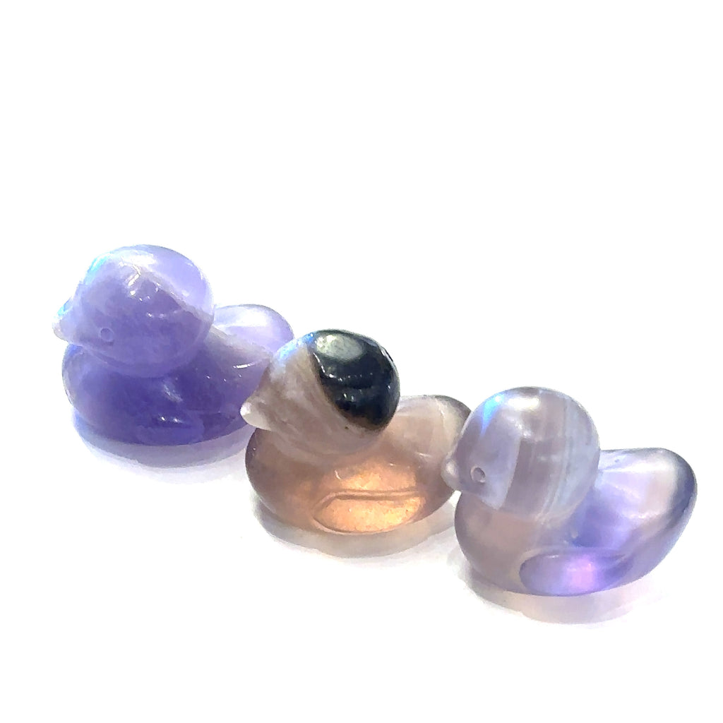 Hand-carved gemstone sculpture of a duck made from Rainbow Fluorite, with a smooth finish on a white background front view