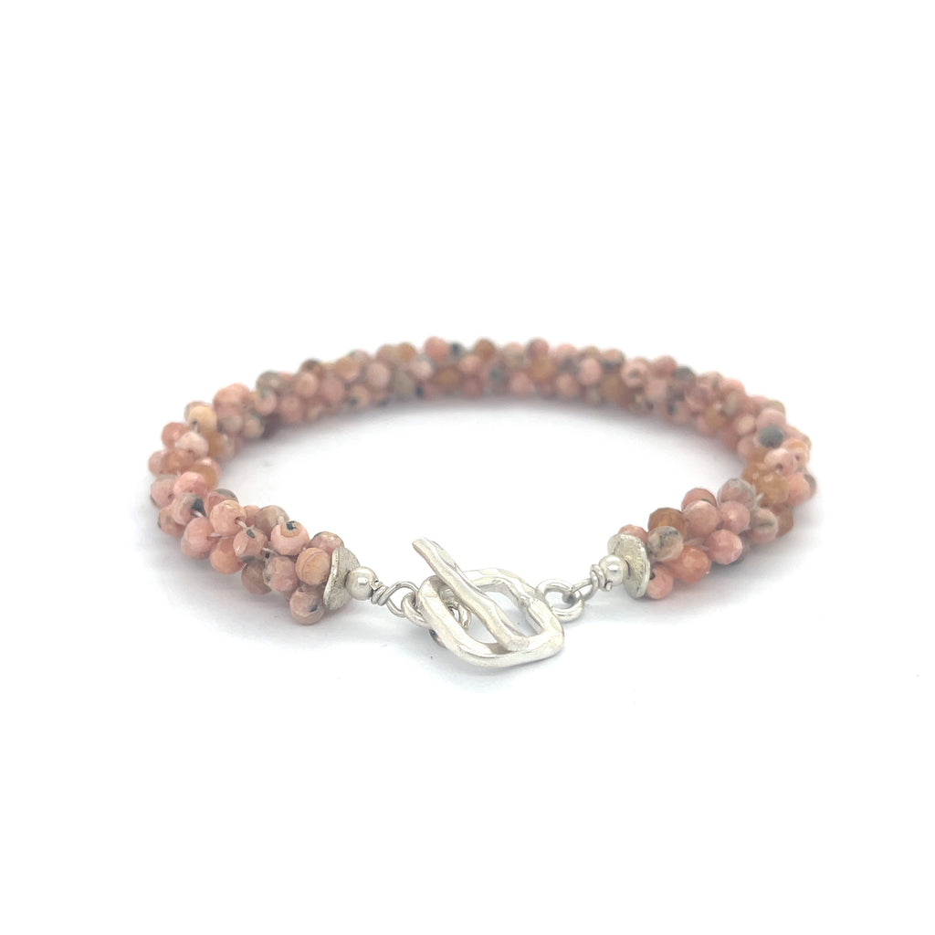Hand-crocheted Rhodochrosite gemstone bracelet with sterling silver  toggle clasp on a white background back center overview of toggle.