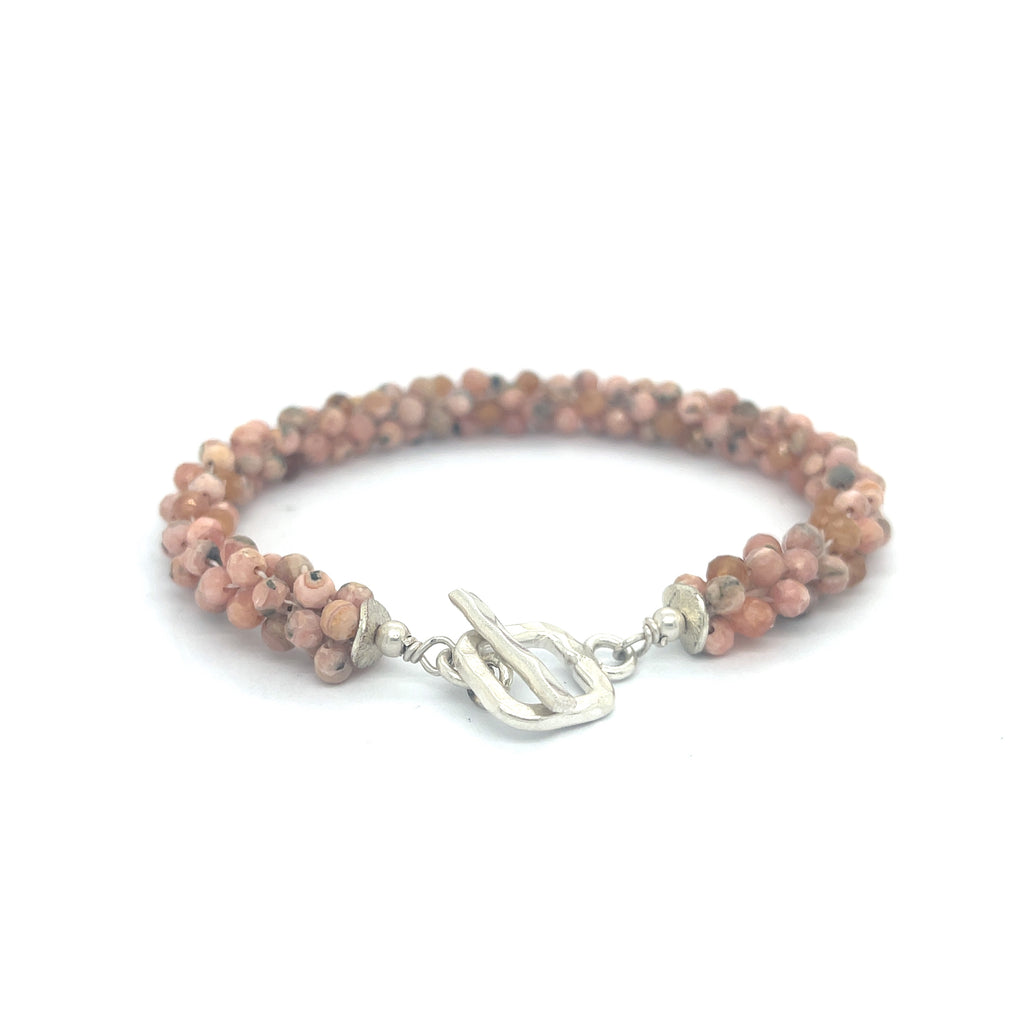 Hand-crocheted Rhodochrosite gemstone bracelet with sterling silver  toggle clasp on a white background back toggle center overview.