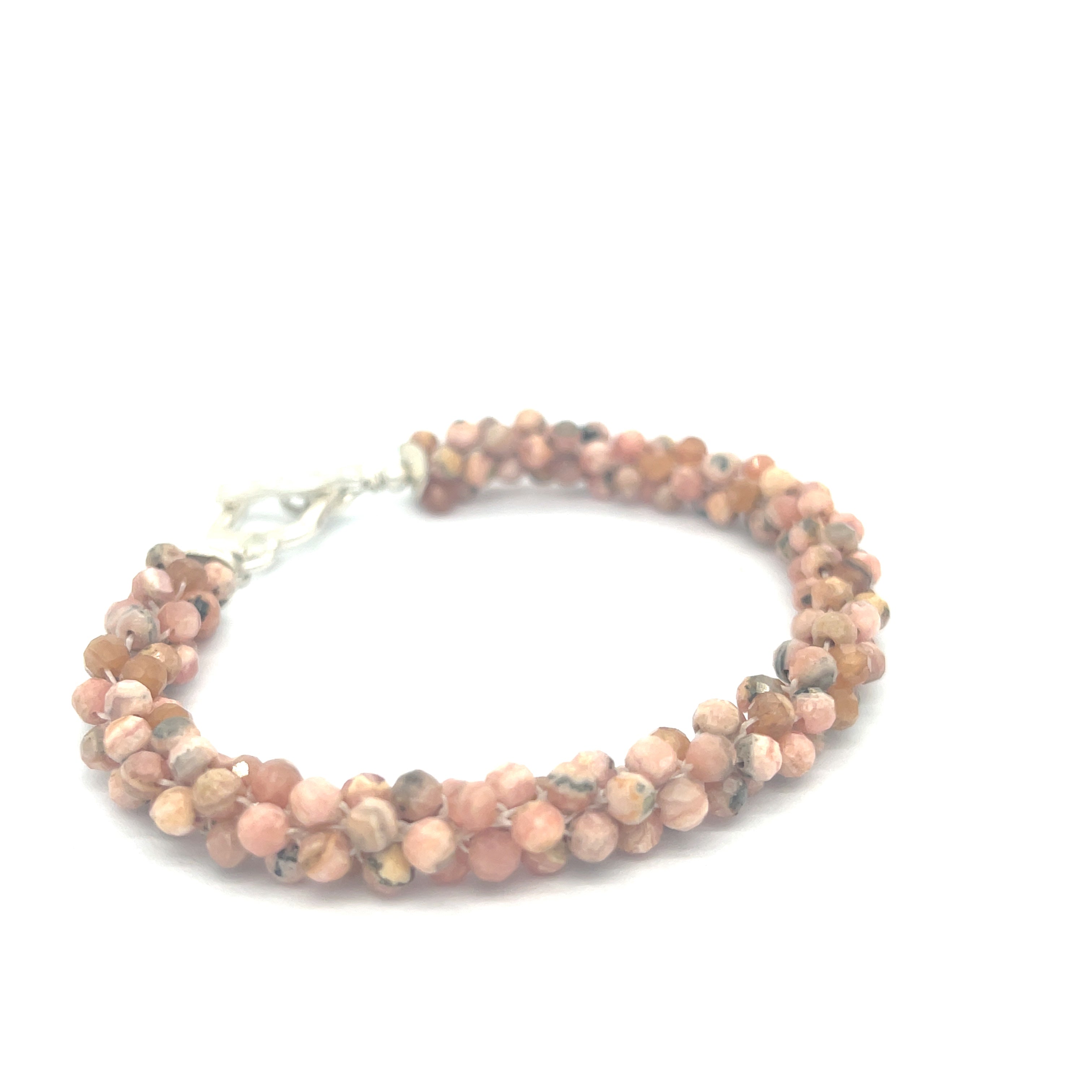 Hand-crocheted Rhodochrosite gemstone bracelet with sterling silver  toggle clasp on a white background front left angle overview.