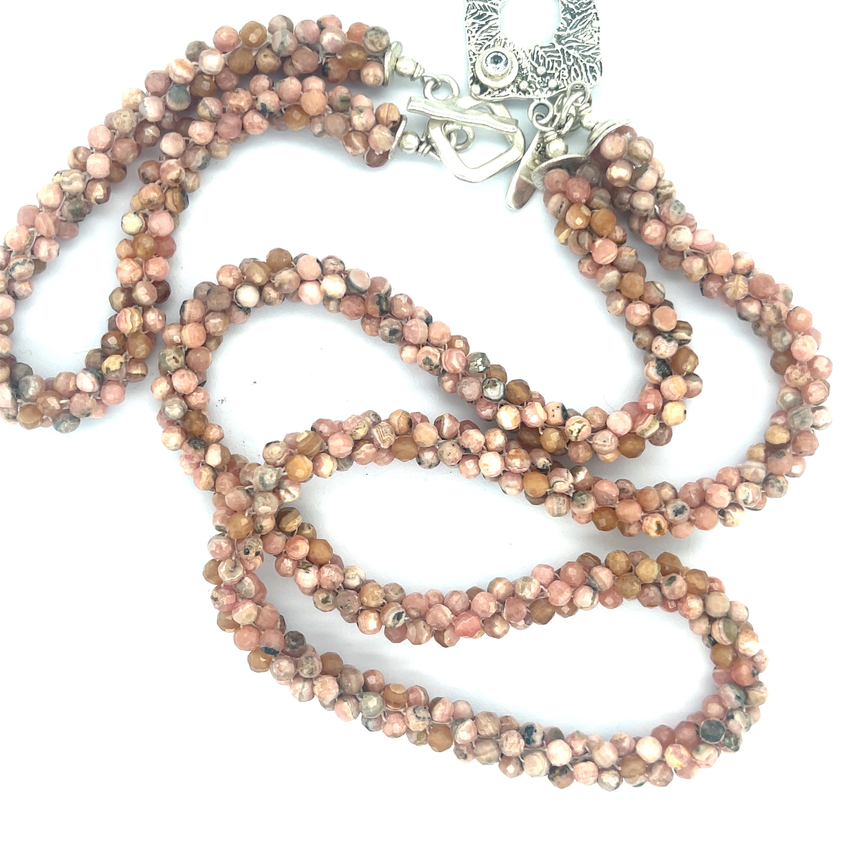 Hand-crocheted Rhodochrosite gemstone necklace with sterling silver toggle and Blue Topaz accent toggle with its matching bracelet  on a white background, a long center close up overview. 