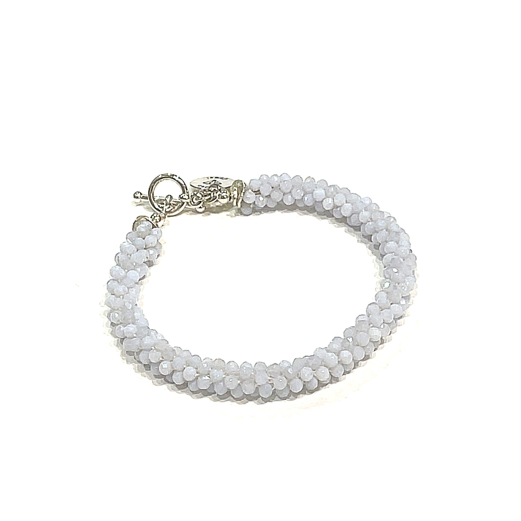 Handcrafted Blue Chalcedony gemstone bracelet on a white background front left angle overview. 