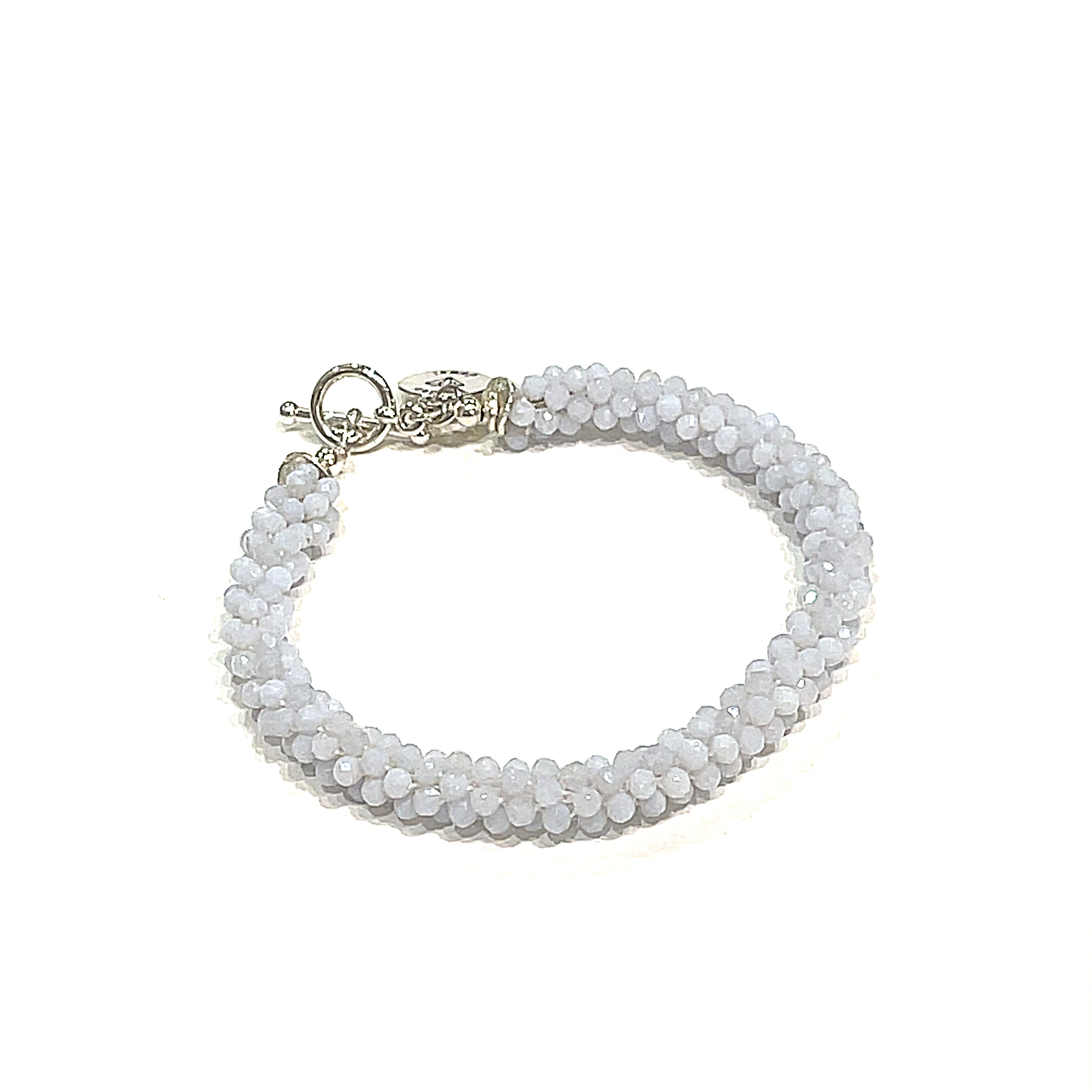 Handcrafted Blue Chalcedony gemstone bracelet on a white background front left angle overview. 
