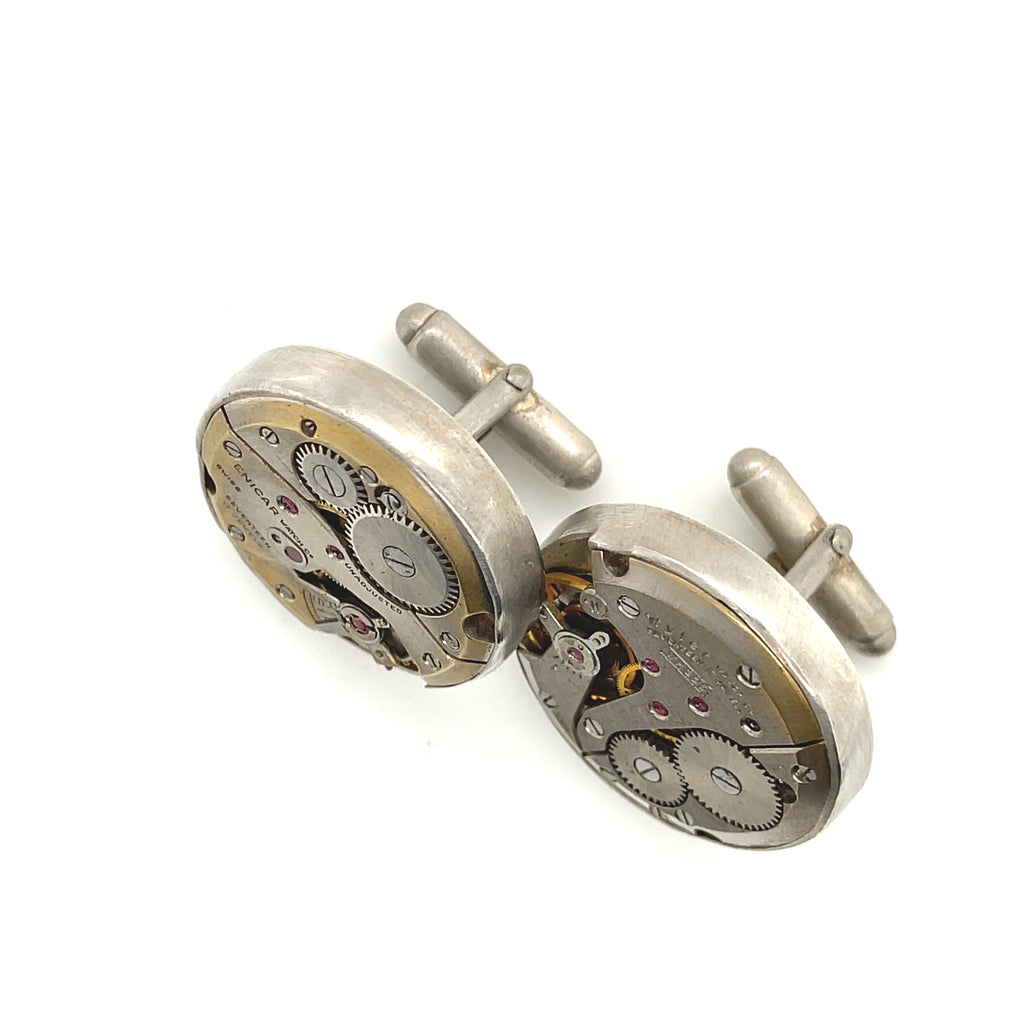 Handcrafted antique watch movement cuff links in sterling silver on a white background front  slight left angle overview. 