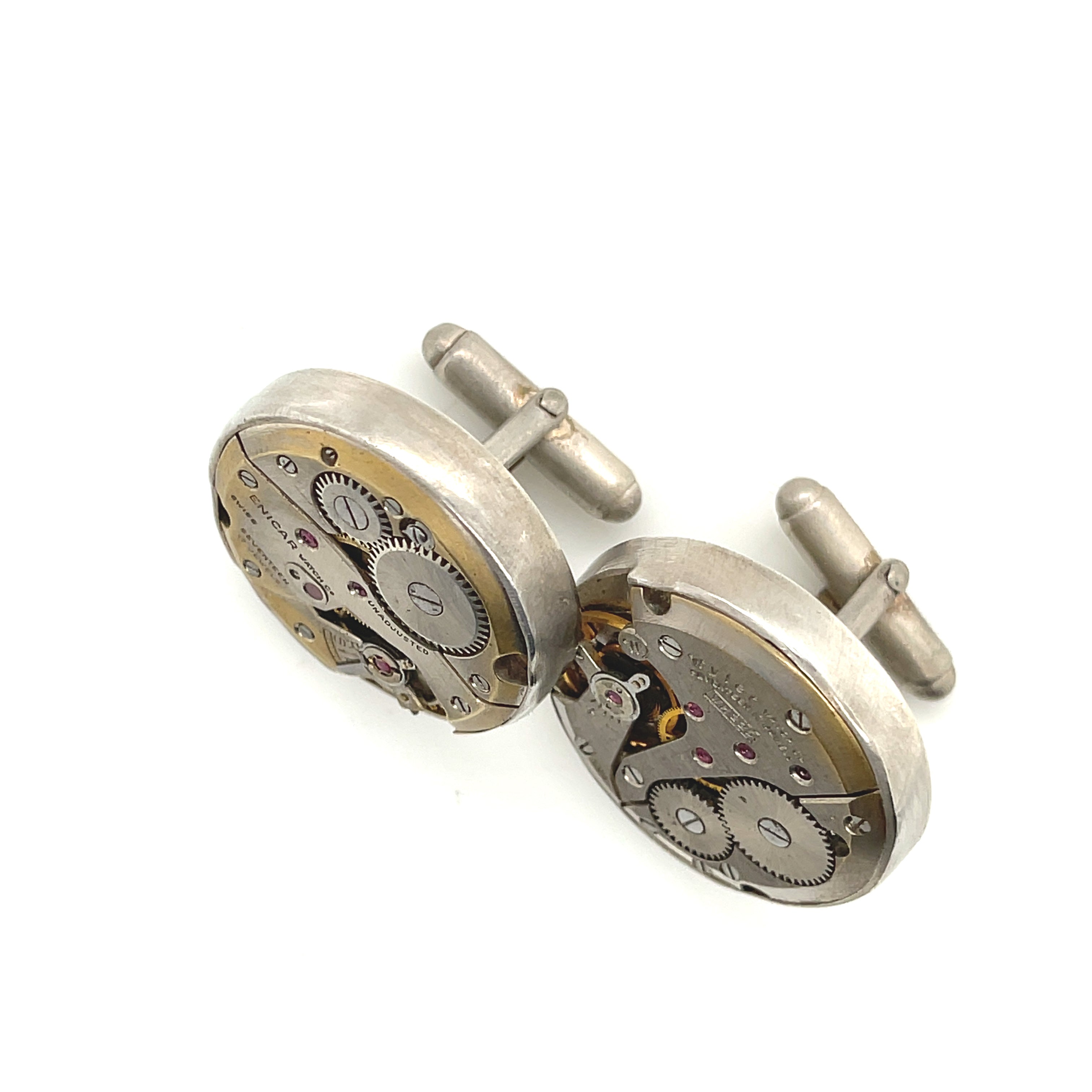 Handcrafted antique watch movement cuff links in sterling silver on a white background front  slight left angle overview. 