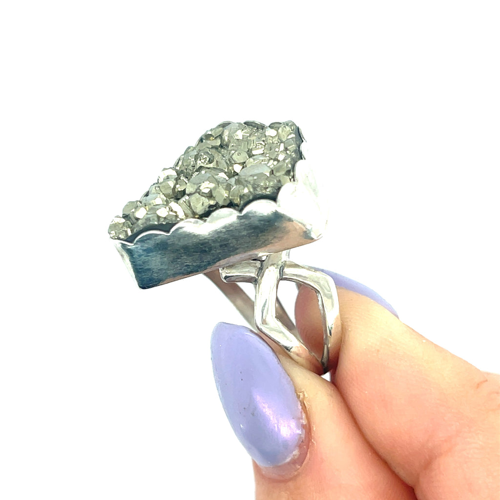 Handcrafted sterling silver Pyrite gemstone ring — Hidden Jewel Boston on a white background with model holding ring in fingertips left side overview. 