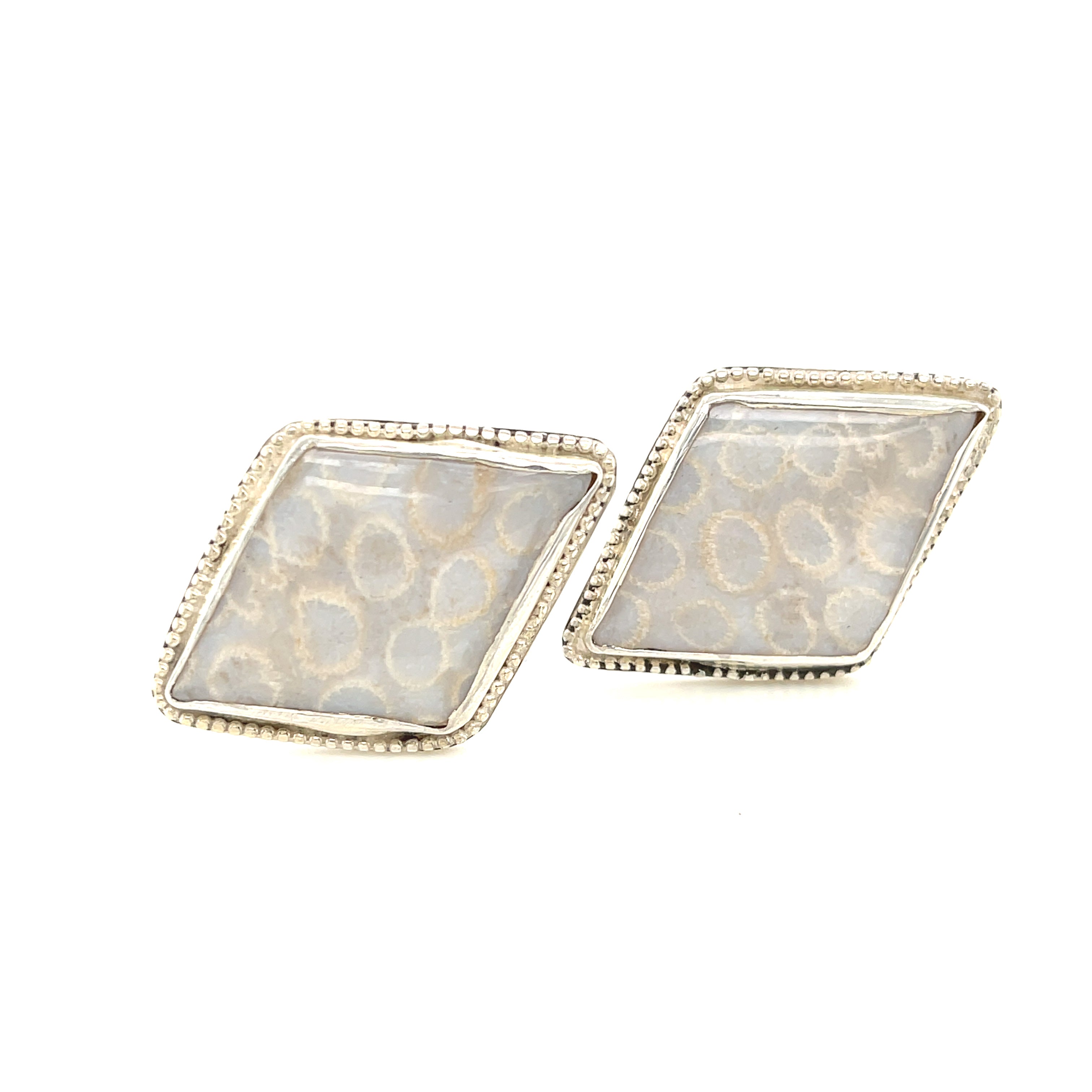 Handcrafted sterling silver fossil coral cuff links with beaded wire design on a white background center forward view.