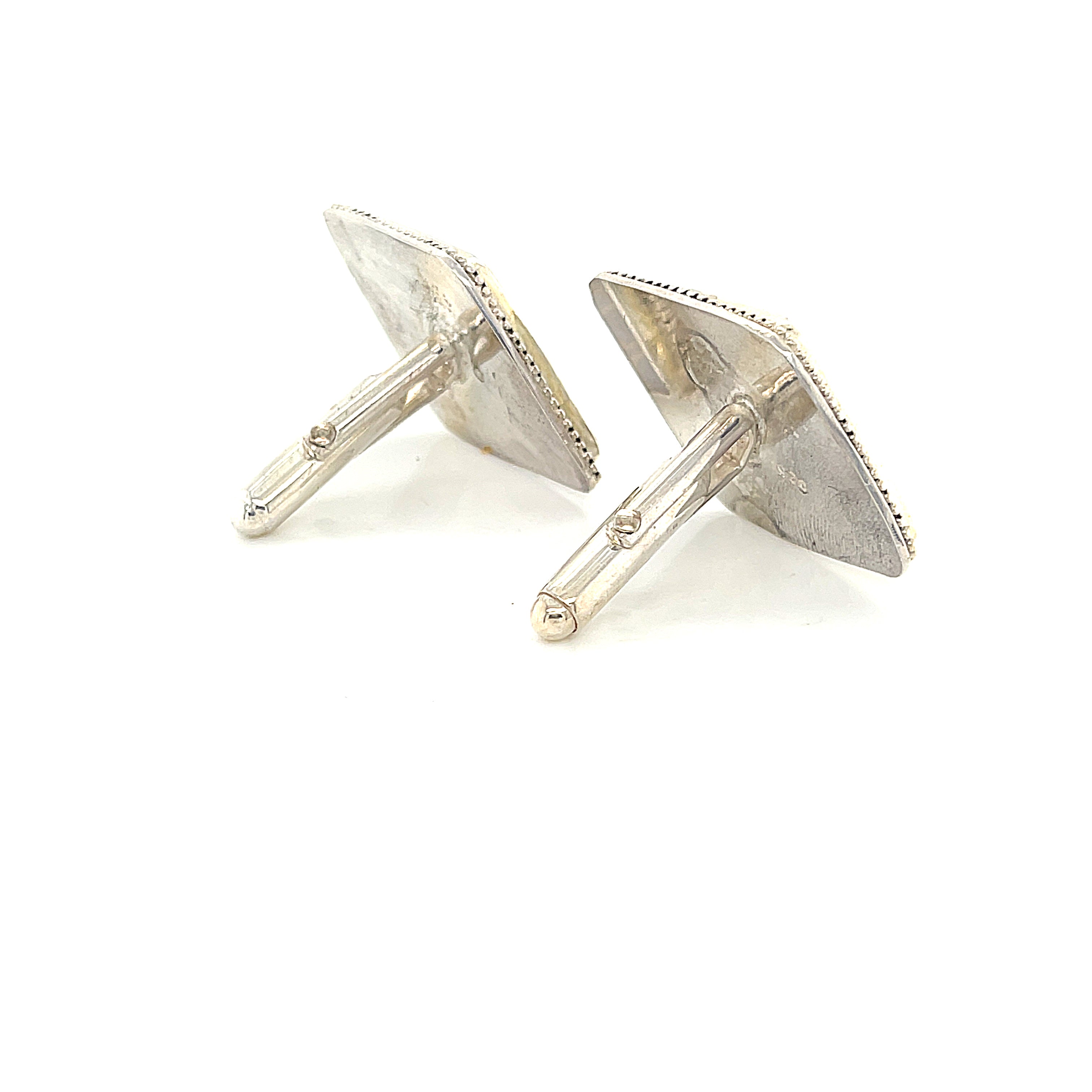 Handcrafted sterling silver fossil coral cuff links with beaded wire design on a white background right angle back view.