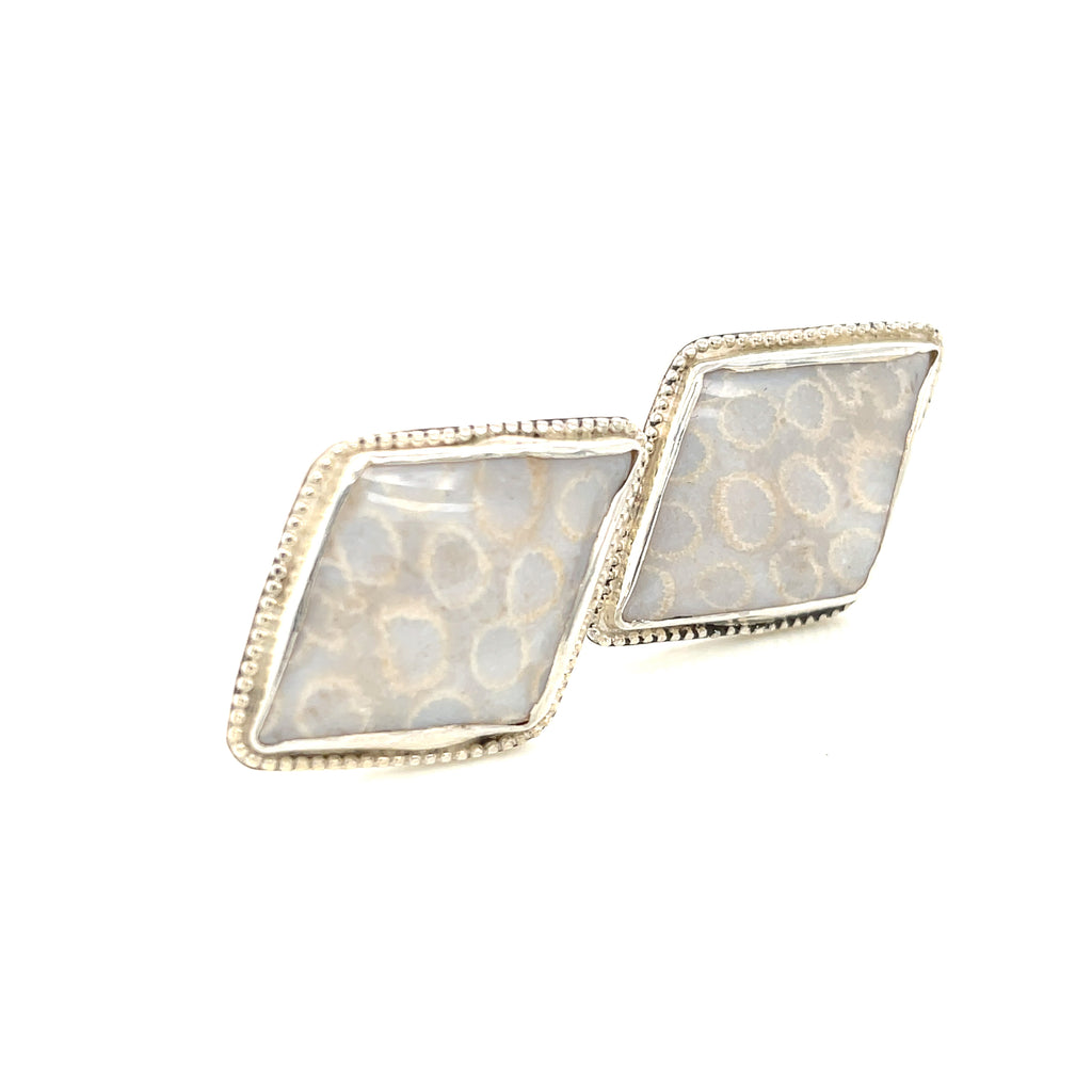 Handcrafted sterling silver fossil coral cuff links with beaded wire design on a white background slight right angle front view.
