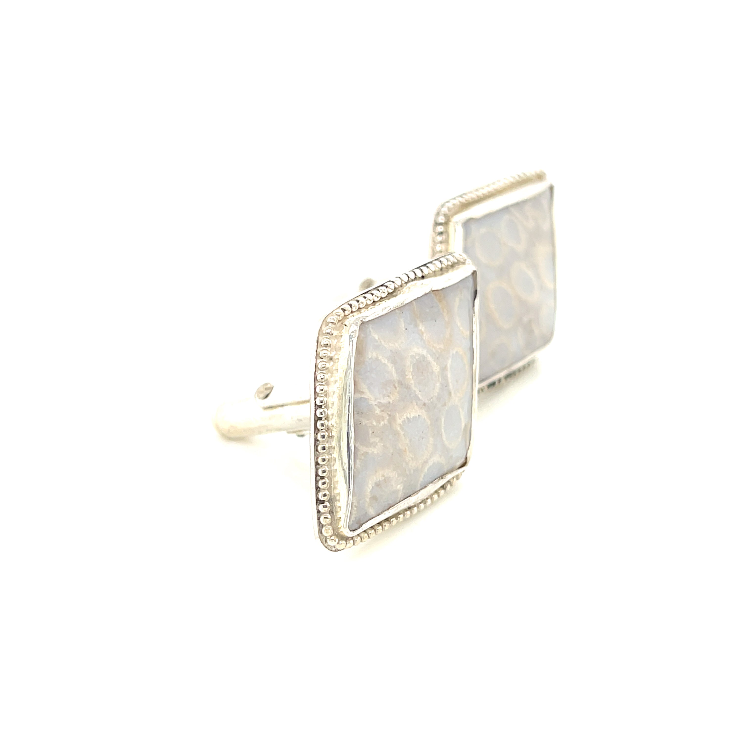 Handcrafted sterling silver fossil coral cuff links with beaded wire design on a white background slight right side view.