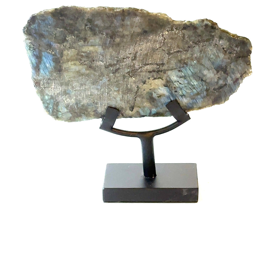 Labradorite slab gemstone on display stand showing vivid labradorescence. On a white background back close up view.