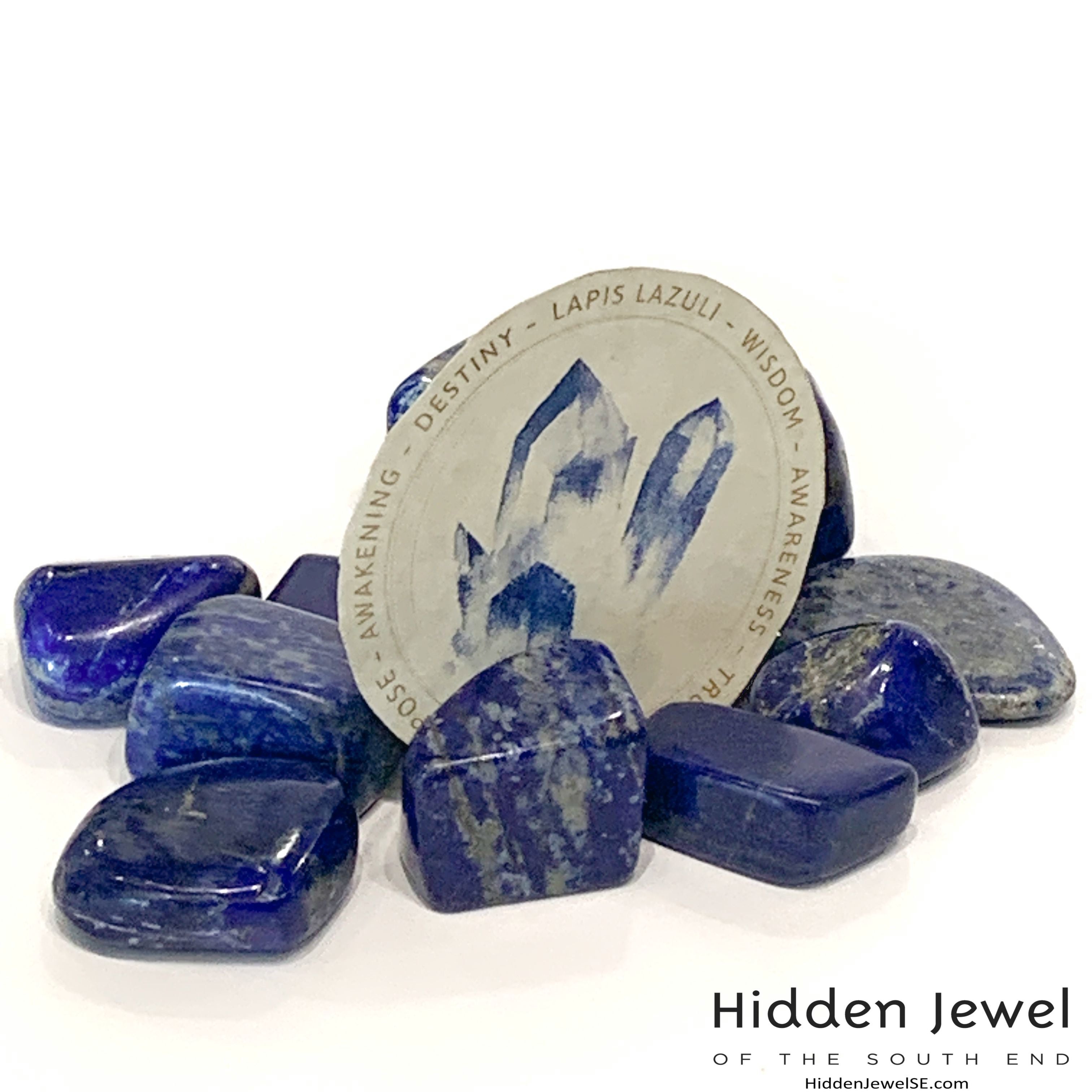 Lapis Lazuli gemstone displayed with printed info card detailing chakra connections and healing meanings on a white background with a front view. 