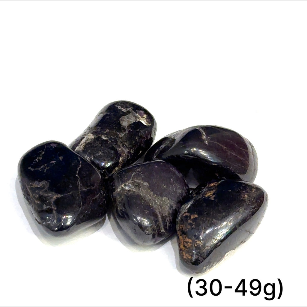 Multiple Purpurite tumbled stones arranged on white background showing variations sizes (301-49g) on white background overview