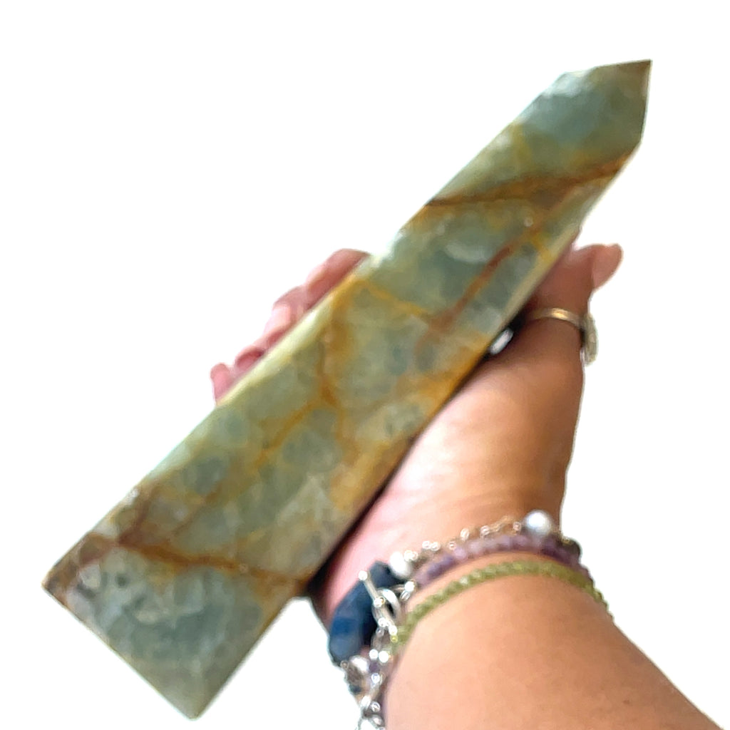 One  3XL large sizes of  blue onyx gemstone towers displayed in a group on a white background, front overview in a models hand to show the size. 