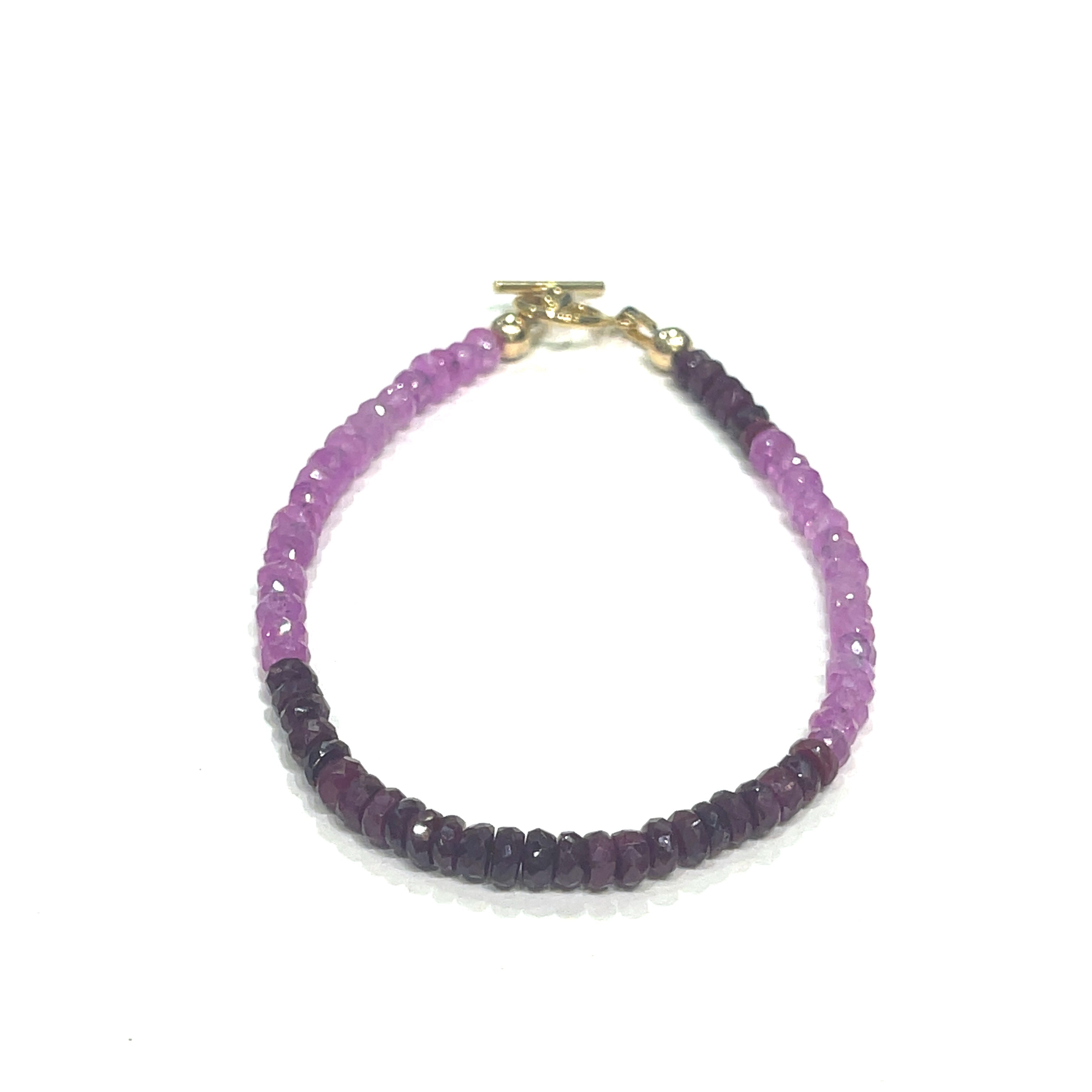 One genuine ruby gemstone beaded bracelet with gold-filled toggle clasps, featuring faceted round rubies ranging from pink to red on a white background, front overview.