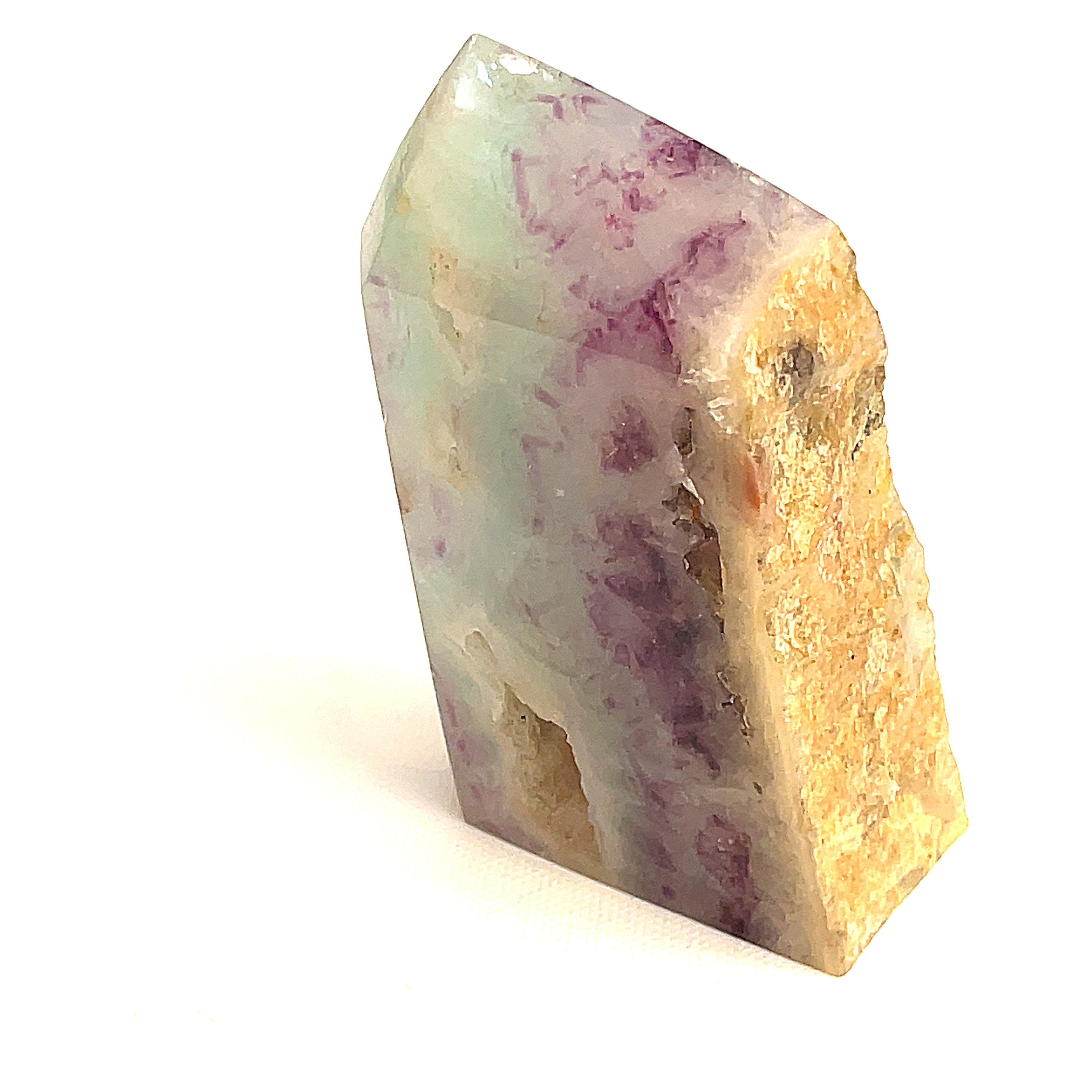 Rainbow Fluorite slab tower with purple and blue banding under light on a white background, front view. 