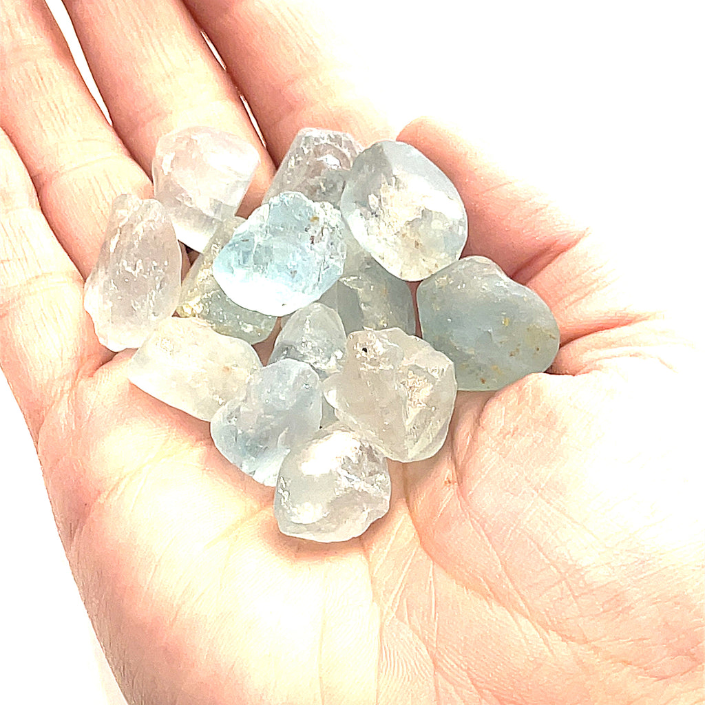 Raw Blue Topaz Gemstone on white grouping center  overview in palm of hand