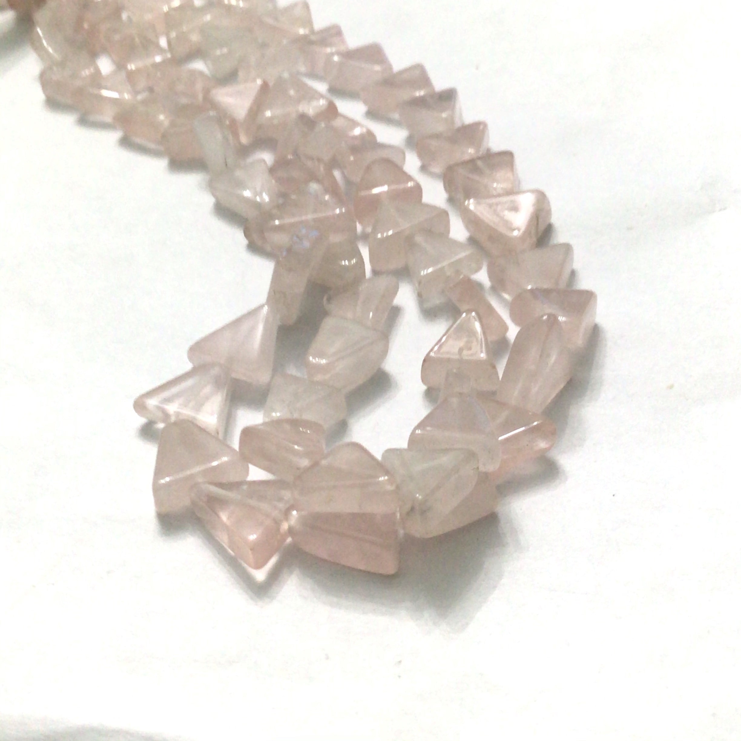 Rose Quartz gemstone beads, smooth Triangles, 15'' strand on a white background, front overview.