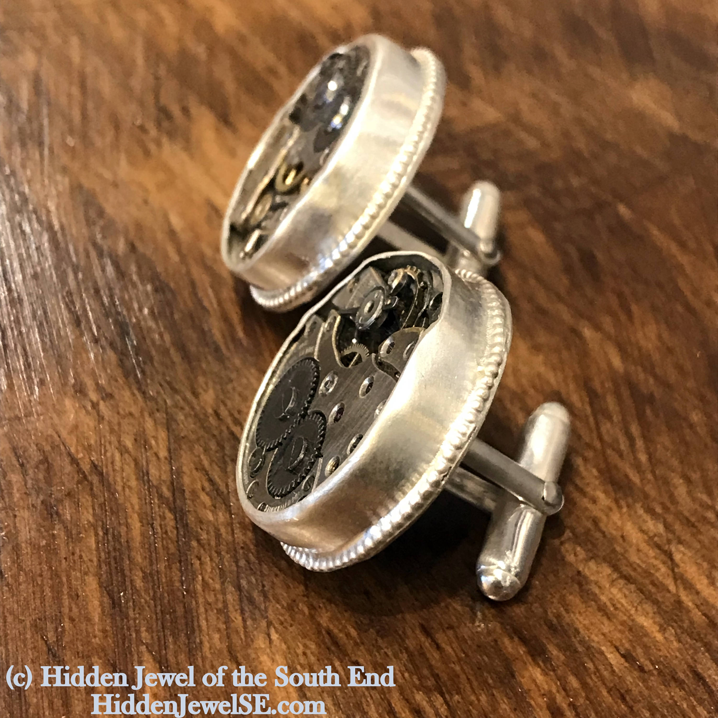 Sterling silver cuff links with mechanical detail handcrafted  in Boston on a wood background  a  left side overview.