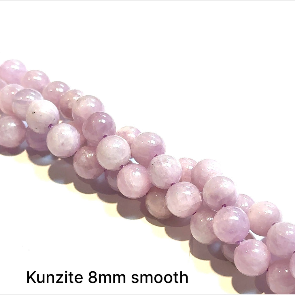 Strand of Kunzite 8mm smooth rounde on a white background, front view.
