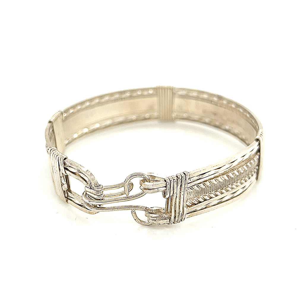 Style #1 Handcrafted sterling silver wire-wrapped bangle with twisted and straight wire combination showing polished dome centerpiece, on a white background, back view. 