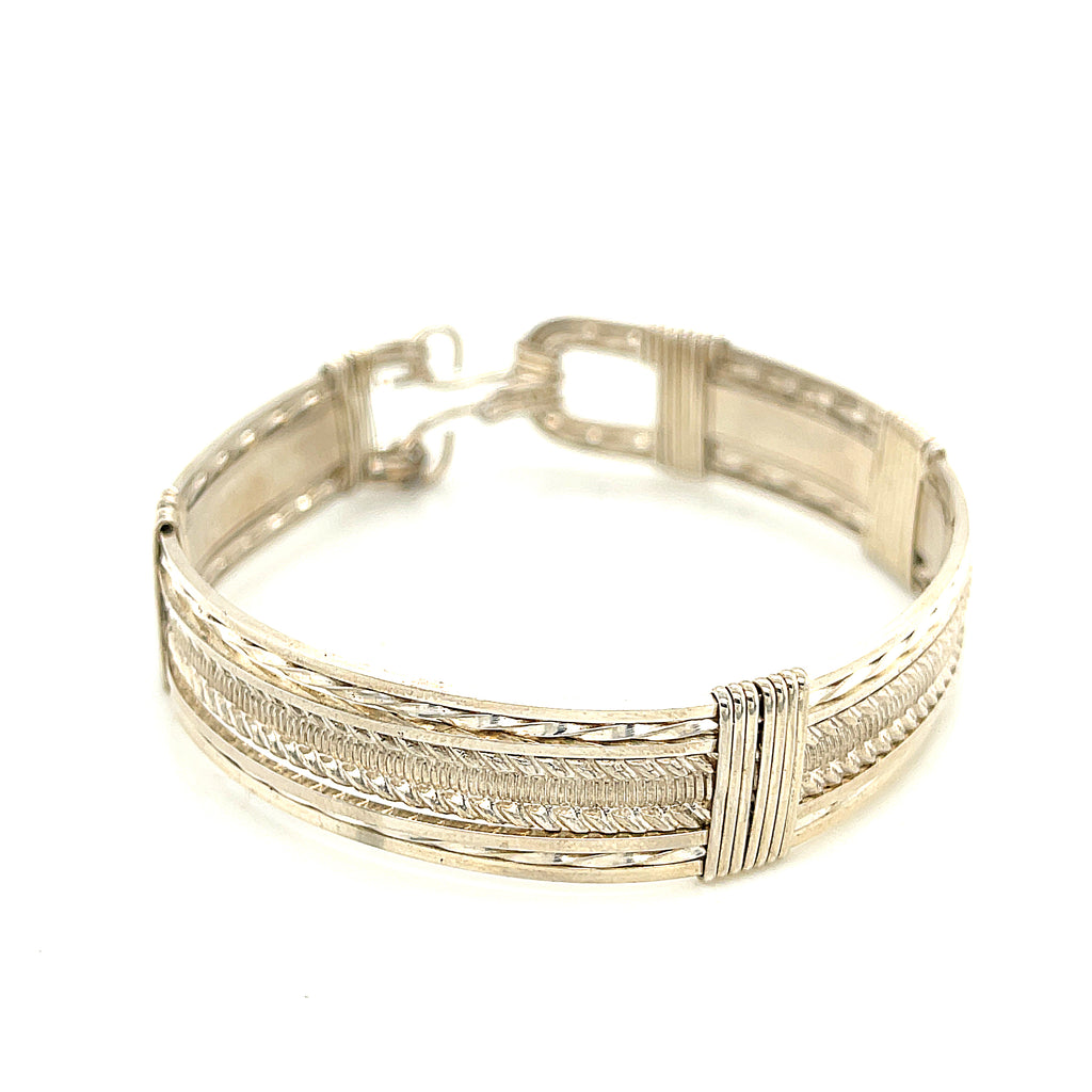 Style #1 Handcrafted sterling silver wire-wrapped bangle with twisted and straight wire combination showing polished dome centerpiece, on a white background, front close up view. 