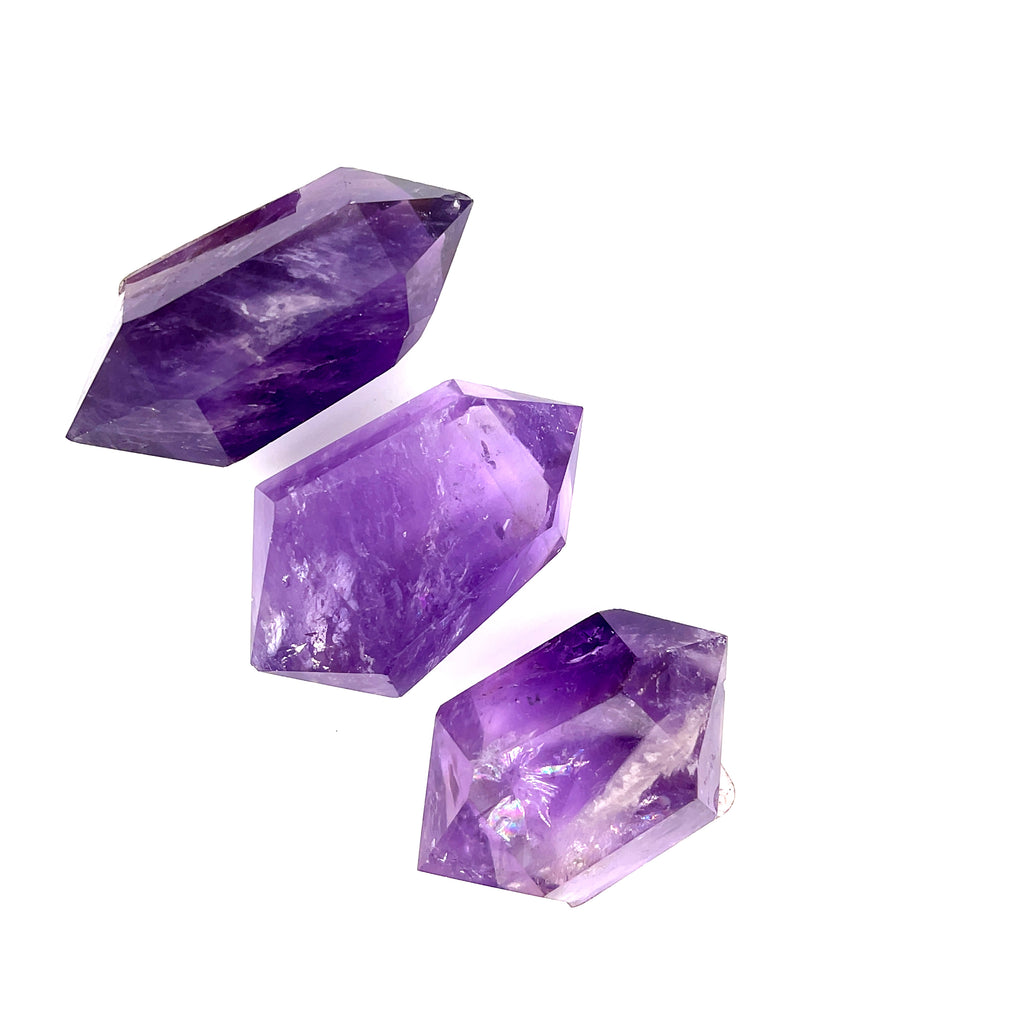 Three Amethyst double terminated stone showing violet facets and natural geometry, on a white background, front overview. 