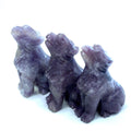 Three Lepidolite howling Dogs gemstone carving on white background, front view. 